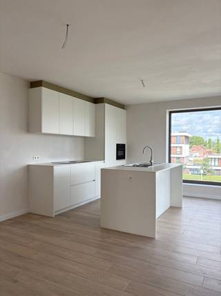 Vraag uw bezoek aan via immodavinci.be<br /><br />Ligging<br /><br />Dit stijlvolle nieuwbouwappartement is uitstekend gelegen in Zwijnaarde, op een strategische locatie nabij het Technologiepark, UZ Gent en AZ Maria Middelares. Dankzij de nabijheid van openbaar vervoer, de E40, E17, R4 en andere belangrijke invalswegen geniet u van een vlotte bereikbaarheid. Winkels en dagelijkse voorzieningen bevinden zich eveneens in de directe omgeving.<br /><br />Indeling<br /><br />De ruime leefruimte baadt in het natuurlijke licht dankzij de grote raampartijen en biedt vrij uitzicht op het omliggende groen. De volledig uitgeruste keuken is voorzien van kwalitatieve, volwaardige toestellen en sluit naadloos aan op de leefruimte.<br /><br />Verder beschikt het appartement over twee ruime slaapkamers, een moderne badkamer en een praktische berging in het appartement. Vanuit de keuken heeft u toegang tot een aangenaam westgericht terras, waar u volop kunt genieten van de namiddag- en avondzon.<br /><br />Op technisch vlak is het appartement uitgerust met vloerverwarming via een warmtepomp, die in de zomer ook kan koelen. Daarnaast zijn er zonnepanelen en een ventilatiesysteem D. Het appartement wordt volledig geschilderd opgeleverd en is voorzien van alle verlichtingsarmaturen.<br /><br />Bij het appartement hoort een autostaanplaats.<br /><br />Troeven<br /><br />EPC A (E-30)<br />2 ruime slaapkamers<br />Grote raampartijen met vrij uitzicht op groen<br />Westgericht terras<br />Warmtepomp<br />Zonnepanelen en ventilatiesysteem D<br /><br />Vrij vanaf 1 september