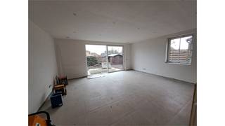 Een gelijkvloers en energie zuinig appartement aangepast aan rolstoelgebruik bestaande uit een woonkamer met open, ingerichte keuken, 2...