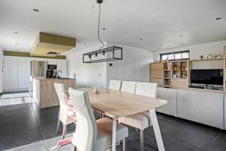 Op een uitstekende locatie in Beerzel (Putte) bevindt zich deze recente villa op een ruim perceel van 825 m². De woning geniet van een rustige, residentiële ligging met een vlotte bereikbaarheid, vlak bij winkels, scholen, openbaar vervoer en invalswegen. Dankzij de polyvalente ruimte met aparte ingang is dit de ideale woning voor wie wonen en werken wil combineren.<br /><br />We betreden de woning via de inkomhal met gastentoilet. De lichtrijke leefruimte met open, volledig ingerichte keuken, vormt het hart van de woning en is uitgerust met een inductiekookplaat, oven, dampkap en ingebouwde vaatwasser. Grote raampartijen over de volledige breedte zorgen voor een mooi zicht op het zonnige, westgerichte terras en de volledig omheinde tuin. Aansluitend bevindt zich nog een praktische berging.<br /><br />De polyvalente ruimte van ca. 28 m² met eigen inkom, wachtruimte en toilet is ideaal als praktijk, kantoor of hobbyruimte.<br /><br />Via de nachthal bereiken we vier ruime slaapkamers en een badkamer met inloopdouche, dubbele lavabo en toilet. Een bergzolder zorgt voor extra opbergruimte.<br /><br />Met een bewoonbare oppervlakte van 221 m² en een EPC-label A (51 kWh/m²) biedt deze woning alle hedendaagse comfort. Dak- en vloerisolatie, driedubbele beglazing en zonnepanelen zorgen voor een bijzonder laag energieverbruik.<br /><br />Bent u op zoek naar een recente, energiezuinige villa met praktijkruimte op een rustige locatie in Beerzel? Contacteer ons via 0474/78 07 73 of www.boonstravastgoed.be<br /><br />Bijzonderheden:<br />• 221 m² bewoonbaar<br />• EPC-label A (51 kWh/m²)<br />• Praktijkruimte met aparte ingang