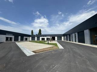 Bedrijfsverzamelgebouw De Rick biedt moderne werkruimte op de voormalige Sega-Meat site aan de Ricksteenweg 23B. Het park omvat 14 casco KMO-units, waarvan er nog 3 beschikbaar zijn.Technische kenmerkenHet gebouw is opgetrokken in duurzame materialen. De draagstructuur bestaat uit stalen spanten en kolommen of betonnen elementen. De gevels combineren betonpanelen van 27 cm met geïsoleerde metalen sandwichpanelen. De vloer is een gewapende betonplaat van 15 cm met 4 cm XPS-isolatie. Het dak in steeldeck is voorzien van minstens 100 mm PIR-isolatie en een lichtstraat voor natuurlijke lichtinval. Vrije hoogte is 7 meter.Uitrusting per unitUnits worden casco geleverd voor eigen inrichting. Elke unit heeft een elektrische sectionaalpoort in antraciet met afstandsbediening en een aluminium loopdeur met bovenlicht. Nutsvoorzieningen omvatten water en elektriciteit (3f400V-40A). Er is een wachtbuis voor data en telefonie.Duurzaamheid en waterElke unit heeft zonnepanelen (+/- 3.600Wp) op het dak. Er is een eigen regenwaterput van 5.000L met aanzuigleiding.Veiligheid en aanlegDe units vallen onder brandklasse C. Er is een brandmeldcentrale met rookdetectoren en een RWA-rookluik aanwezig. De rijweg is van asfalt; parkings en opritten bestaan uit drainerende betonklinkers. Gemeenschappelijke delen omvatten een brievenbusgeheel en een fietsenstalling voor circa 20 fietsen