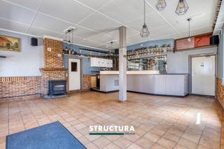 Wonen en werken onder één dak? Dit veelzijdige handelshuis in het centrum van Brussegem biedt een interessante combinatie van ruimte, karakter en mogelijkheden. De eigendom beschikt over een handelsgedeelte op het gelijkvloers en een ruim woongedeelte met drie slaapkamers op de verdieping. De ligging in de dorpskern zorgt bovendien voor een goede bereikbaarheid en een vlotte verbinding met de omliggende gemeenten.Wat deze eigendom bijzonder maakt, is de flexibele invulling die de verschillende ruimtes toelaten. Het gelijkvloers, dat jarenlang dienstdeed als café, beschikt over een grote open ruimte waarin de oorspronkelijke toog nog aanwezig is. Dit biedt een interessante basis voor wie een eigen handelsactiviteit wil uitbouwen of op zoek is naar een pand dat wonen en werken combineert. Ook voor wie het geheel een nieuwe invulling wil geven, zijn er verschillende mogelijkheden.IndelingGelijkvloers: ruime handelsruimte met originele toog, aansluitende eetruimte en keuken op kelderniveau.Eerste verdieping: drie ruime slaapkamers, een ingerichte badkamer en een bijkomende ruimte die als dressing of berging kan worden gebruikt.Karakteristieken- Gelegen in de dorpskern van Brussegem- Voormalig café met ruime handelsoppervlakte- Authentieke elementen- Interessant renovatie- en herinrichtingspotentieel- Vlotte verbinding richting Merchtem, Asse en WemmelDit handelshuis is een interessante opportuniteit voor wie op zoek is naar een eigendom met verschillende gebruiksmogelijkheden. Met de nodige opfrissing en een persoonlijke invulling kan hier een aangename combinatie van wonen en ondernemen worden gerealiseerd.Benieuwd naar de mogelijkheden van dit pand? Contacteer Structura via 02 460 80 46 of info@structura.be en plan uw bezoek!