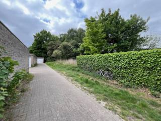Grond met mogelijkheid tot het oprichten van een bergplaats, atelier of werkplaats voor een kleine zelfstandige. Het betreft een achterin gelegen onbebouwd perceel met oprit bereikbaar via een inrit naar diverse garageboxen en werkplaatsen. Het te bebouwen perceel heeft een oppervlakte van ca. 700 m². Een bouwaanvraag dient met de stadsdiensten verder afgetoetst te worden. Vermelde afmetingen/oppervlakten zijn indicatief.