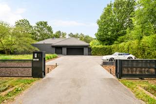 Située dans un environnement exceptionnellement calme et verdoyant, cette villa exclusive offre une combinaison unique de luxe, de confort et d'intimité. La propriété dispose de 2 à 4 chambres, d'un espace bien-être complet, d'une piscine intérieure et extérieure et de finitions de haute qualité, entièrement intégrées dans le paysage naturel.<br /><br />Rez-de-chaussée:<br /><br />Par le hall d'entrée élégant avec un grand vestiaire et des toilettes pour les invités, vous accédez aux différents espaces de vie, aux chambres au rez-de-chaussée et à l'étage.<br /><br />Lors de la conception de la maison, une attention particulière a été portée à un équilibre optimal entre l'intimité et une forte connexion avec les espaces de vie et le jardin. La cuisine centrale est le cœur de la maison et relie la salle à manger au salon. Cette cuisine de vie luxueusement équipée comprend notamment une plaque à induction avec Teppanyaki, un four, un micro-ondes, un réfrigérateur américain, des armoires à vin et une table de bar réglable en hauteur avec refroidisseur à vin intégré.<br /><br />La salle à manger et le coin salon sont élégamment séparés par une cheminée au gaz chaleureuse. De grandes baies vitrées assurent une transition fluide vers la terrasse orientée sud avec jacuzzi intégré, piscine à débordement et accès direct à la piscine intérieure au niveau -1.<br /><br />À côté se trouve une charmante salle de jardin avec sa propre cuisine, coin salon avec cheminée en bois et un grand espace repas. Un endroit idéal pour profiter de la vue sur le jardin toute l'année.<br /><br />En outre, le rez-de-chaussée dispose d'un salon supplémentaire avec cheminée en bois, qui peut être utilisé séparément grâce à des portes pivotantes élégantes.<br /><br />La suite parentale luxueuse est équipée de la climatisation, d'une cheminée au gaz et d'une télévision. La salle de bains attenante respire une élégance pure avec une grande baignoire, un double lavabo en marbre Marron Emperador, une douche à l'italienne en mosaïque de verre et des toilettes séparées. Depuis la chambre, vous avez un accès direct à la terrasse orientée est. Le dressing sur mesure avec éclairage indirect complète cet ensemble exclusif.<br /><br />La deuxième chambre dispose également de sa propre salle de bains avec double vasque et douche à l'italienne.<br /><br />À côté de la cuisine se trouve le double garage intégré. Les installations de lavage et de séchage sont discrètement intégrées dans des armoires sur mesure. Il y a également un accès à la salle des machines.<br /><br />Étage:<br /><br />L'étage est actuellement aménagé en salle de fitness professionnelle, bureau et chambre supplémentaire.<br /><br />Sous-sol:<br /><br />Le sous-sol est entièrement dédié à la détente et au bien-être. Vous y trouverez une grande piscine intérieure, un sauna et une salle de douche. La salle des machines comprend, entre autres, les installations pour la piscine, le chauffage et le système de ventilation.<br /><br />Jardin:<br /><br />Le jardin magnifiquement aménagé est un véritable paradis privé. La piscine à débordement avec cascade, douche extérieure, diverses terrasses et coins salon chaleureux font de cet espace extérieur une expérience unique. La terrasse orientée sud offre une orientation optimale au soleil et une vue magnifique sur le vert environnant.<br /><br />De plus, le jardin dispose d'un spacieux poolhouse avec douche, lavabo et toilettes.<br /><br />L'architecte a créé un jardin facile d'entretien qui s'intègre parfaitement dans le paysage naturel. Grâce à une plantation réfléchie et un éclairage d'ambiance, vous pourrez profiter ici d'une intimité maximale en toute tranquillité. Le jardin est entièrement clos du côté de la rue et ne permet aucun vis-à-vis.<br /><br />Caractéristiques:<br />*Récemment rénové (2024), nouveau toit et nouveaux sols.<br />*Équipé de panneaux solaires, installés en 2023.<br />*L'installation de chauffage de la maison et de la piscine a été renouvelée en