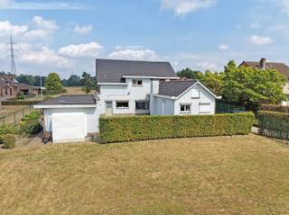 <p><span>Deze ruime woning is gebouwd in ±1966 en is gelegen op een perceel van ±13a 87ca. </span></p><p><span> </span></p><p><span>Via een automatische poort bereikt u de ruime parking aan de woning. </span></p><p><span> </span></p><p><span>Vanuit de inkomhal met gastentoilet krijgt u toegang tot het ruime leefgedeelte, bestaande uit een gezellige living met haard (±33m²), een eetplaats en een afzonderlijke tv-hoek (±27m²). Aansluitend bevindt zich de leefkeuken met achterliggende bijkeuken (±21m²). Verder beschikt het gelijkvloers over een afzonderlijke bureauruimte (±12m²), een berging (±8.5m²) en een wasplaats (±6m²) met rechtstreekse toegang tot het terras. </span></p><p><span> </span></p><p><span>Op de verdieping bevinden zich vijf slaapkamers (±12.5m², 16.5m², 11m², 11m² en 10.5m²). De masterbedroom geeft toegang tot een terras en geniet van een mooi uitzicht over de tegenoverliggende velden. Daarnaast beschikt één slaapkamer over een eigen douche en wastafel, terwijl een andere slaapkamer voorzien is van een wastafel. De badkamer is uitgerust met een ligbad, wastafel en toilet. (±10.5m²)</span></p><p><span> </span></p><p><span>Verder beschikt de woning over een driedubbele inpandige garage, een kleine kelder en is voorzien van een volledige kruipkelder.</span></p><p><span> </span></p><p><span>Dankzij de ruime indeling en de zuidwestelijke oriëntatie biedt deze eigendom van heel wat mogelijkheden.</span></p><p><span> </span></p><p><span>Extra's: 4 parkeerplaatsen, alarmsysteem, airco, ramen in aluminium (2012), volledig omheind, deuren en trap in massief eikenhout, haard, natuursteen, septische put, ...</span></p><p><span> </span></p><p><span>Uitbreiding garage 1973.</span></p><p><span>Uitbreiding zithoek, berging en wasplaats 1980.</span></p><p><span> </span></p>