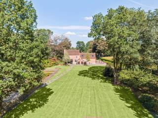 Amidst an exceptionally beautiful estate of approximately 8 hectares of forest stands this characterful property from 1930, which was completely renovated in 2014-2015 with an emphasis on quality, comfort, and preservation of its authentic appearance. The house is surrounded by a beautiful garden with a well-maintained vegetable garden and, thanks to the wooded surroundings, offers a unique combination of tranquility, privacy, and nature experience. The fully enclosed plot also has a charging station for an electric car.<br /><br />Ground floor<br />The entrance hall with guest toilet provides access to the various living areas of the house. The spacious and charming living room enjoys a beautiful view of the garden and, together with the kitchen and additional sitting area, forms the warm heart of the home.<br /><br />The luxuriously furnished kitchen is equipped with a pleasant breakfast nook and high-quality appliances: coffee machine, refrigerator, freezer, dishwasher, microwave, convection oven, and a Falcon stove. Adjacent to the kitchen is a practical storage space.<br /><br />Furthermore, on the ground floor, you will find an additional sitting area with a wood-burning stove. Thanks to the beautiful view of the garden, this is a particularly pleasant place to relax.<br /><br />The very spacious laundry room is equipped with numerous custom-made cabinets and offers a lot of practical storage space. There is also a separate boiler room.<br /><br />First floor<br />Via the stairs, you reach the first floor, where there are three pleasant bedrooms. The rooms are equipped with air conditioning and enjoy the peace and green surroundings. Furthermore, this floor has a fitted bathroom and a spacious dressing room with beautifully crafted, custom-made cabinets. This dressing room offers so much space and potential that it can also be perfectly furnished as a fourth bedroom.<br /><br />Garden<br />An absolute asset of this property is its exceptional location on an estate of approximately 8 hectares of forest. The house is surrounded by a beautiful, well-kept garden with a vegetable garden, ensuring that living here guarantees peace, privacy, and an intense connection with nature. The fully enclosed plot offers numerous possibilities for those looking for space and privacy in an exceptionally wooded environment.<br /><br />Extraordinary features<br />• Characterful property from 1930, completely renovated in 2014-2015<br />• Located on an exceptional estate of approximately 8 hectares of forest<br />• Beautiful wooded and peaceful surroundings<br />• Beautifully landscaped garden with vegetable garden<br />• Luxury kitchen with breakfast nook and high-quality appliances<br />• Falcon stove, coffee machine, refrigerator, freezer, dishwasher, microwave, and convection oven<br />• Additional sitting area with charming wood-burning stove and beautiful garden view<br />• Spacious living room<br />• Very spacious laundry room with custom-made cabinets<br />• 3 bedrooms, with the possibility of a 4th bedroom<br />• Spacious dressing room with custom-made cabinets<br />• Fitted bathroom<br />• Air conditioning in the kitchen, living room, and all bedrooms<br />• Central vacuum system<br />• Oil heating<br />• Luxury finish with high-quality and beautiful materials<br />• Fully enclosed plot<br />• Charging station for electric car available