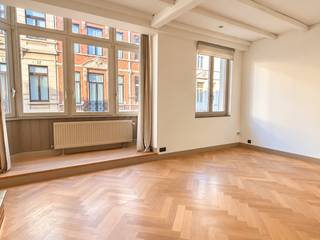 Dit appartement, dat dankzij de ruime indeling en de verdeling over meerdere verdiepingen het gevoel van een volwaardige woning biedt, bevindt zich achter een charmante gevel in een kleinschalig gebouw. De inkomhal wordt slechts gedeeld met één andere woning, die zich achteraan in het gebouw bevindt.<br /><br />U betreedt de woning via de inkomhal op het gelijkvloers, die toegang biedt tot een aparte wasplaats, een gastentoilet en de kelder. Via de traphal bereikt u de eerste verdieping, waar de leefruimte en keuken zich bevinden. De ruime leefruimte geniet aan de voorzijde van een karaktervolle erker, terwijl de volledig geïnstalleerde keuken zich achteraan bevindt. Vanuit de keuken is er rechtstreeks toegang tot het riante en zonnige terras, dat volledig vernieuwd werd.<br /><br />Op de tweede verdieping bevinden zich de twee slaapkamers en de badkamer. De master bedroom beschikt over een aansluitende dressing en een eigen balkon. De badkamer is uitgerust met een dubbele lavabo en een ruime inloopdouche en bevindt zich, samen met de tweede slaapkamer, aan de achterzijde. Verder is er op deze verdieping een afzonderlijk toilet en een handige ingebouwde kast aanwezig.<br /><br />Gemeenschappelijke lasten: 45 Euro per maand.<br /><br />Provisie voor het verbruik van water: 35 Euro per maand.<br />De nutsvoorzieningen gas en elektriciteit zijn privé op te nemen door de huurder.<br /><br />Onmiddellijk beschikbaar.
