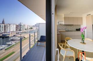 <strong>Exclusief wonen op een toplocatie in Oostende</strong><br /><br />Op zoek naar een instapklaar appartement te huur in Oostende?<br />Dit volledig gerenoveerde en smaakvol gemeubelde appartement op de <strong>8ste verdieping van Residentie De Ra</strong> biedt een uitzonderlijke woonervaring met een panoramisch uitzicht op de <strong>Mercator</strong>, de <strong>jachthaven</strong> en de stad.<br />Dankzij de centrale ligging bevindt u zich op wandelafstand van winkels, restaurants, het station, de zee en alle voorzieningen die Oostende te bieden heeft.<br /><br /><strong>Lichtrijke leefruimte met adembenemend uitzicht</strong><br />De ruime en gezellige woonkamer geniet van grote raampartijen die zorgen voor een overvloed aan natuurlijk licht.<br />Vanuit de leefruimte heeft u toegang tot het terras, waar u elke dag kunt genieten van een uniek en blijvend open zicht op de Mercator en de jachthaven.<br /><br /><strong>Moderne open keuken</strong><br />De stijlvolle open keuken is volledig geïntegreerd in de leefruimte en beschikt over een moderne afwerking.<br />Ideaal voor wie houdt van comfortabel en eigentijds wonen.<br /><br /><strong>Twee rustige slaapkamers</strong><br />Achteraan het appartement bevinden zich 2 volwaardige slaapkamers, beide uitgevend op een tweede terras met een aangenaam open uitzicht.<br /><br /><strong>Comfortabele badkamer</strong><br />De moderne badkamer is uitgerust met een inloopdouche en lavabo, en werd afgewerkt met kwaliteitsvolle materialen.<br /><br /><strong>Extra troeven</strong><br /><span>Volledig gemeubeld</span><br /><span>Uniek zicht op de Mercator en de jachthaven</span><br /><span>Parking aan de residentie</span><br /><br /><strong>Praktische informatie</strong><br /><span><strong>Beschikbaar:</strong> vanaf <strong>1 september (of in overleg)</strong></span><br /><span><strong>Bewoonbare oppervlakte:</strong> 77 m² + terrassen</span><br /><span><strong>EPC:</strong> 233 kWh/m²/jaar</span><br /><span>Provisie gemeenschappelijke kosten<strong>:</strong> € 150 per maand</span><br /><span>Centrale verwarming op aardgas</span><br /><br /><strong>Interesse?</strong><br />Bent u op zoek naar een gemeubeld appartement met twee slaapkamers, terras en een uniek uitzicht in het hart van Oostende? Neem dan vandaag nog contact op voor meer informatie of een bezichtiging.<br /><br />Dit instapklare appartement combineert comfort, een uitstekende ligging en een uitzonderlijk uitzicht op een van de mooiste locaties van Oostende.<br />