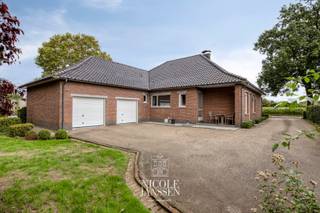 Dit verzorgde huis is verrassend ruim ingedeeld en erg praktisch aangezien men volledig gelijkvloers kan wonen. De woning werd gebouwd met degelijke materialen en is altijd perfect onderhouden geweest. De dubbele inpandige garage, extra bureelruimte en nog verder in te richten/ af te werken zolder bieden extra veel mogelijkheden.<br /><br />=> Ligging<br />De woning is gelegen op een goed bereikbare locatie, op enkele kilometers van zowel Maaseik-centrum als de Nederlandse grens richting Stramproy en Weert. Winkels, scholen en andere dagelijkse voorzieningen zijn vlot bereikbaar. Grote troef is dat dit perceel is ook via de achterliggende straat te bereiken is.<br /><br />=> Gelijkvloers<br />- Inkomhal met apart gastentoilet en vestiaireruimte<br />- Leefruimte met inbouwhaard en veel lichtinval door de vele raampartijen<br />- Eetkamer<br />- Verzorgde eiken keuken met veel werkruimte <br />- Naast de keuken is nog een bureelruimte<br />- Drie slaapkamers<br />- Betegelde badkamer voorzien van ligbad, douche en dubbele wastafel<br />- Betegelde wasplaats met ruim badkamermeubel<br />- Dubbel inpandige garage met automatische poorten<br />- Voldoende bergruimte in de garage<br /><br />=> Verdieping<br />- De zolder wordt momenteel gebruikt als opbergruimte. <br />- Kan naar eigen wens en behoefte nog verder afgewerkt en ingericht worden<br /><br />=> Kelder<br />- Deels onderkelderd en deels kruipkelder<br /><br />=> Tuin<br />- Via de Bomerstraat is er toegang tot de achterzijde van de woning<br />- Voldoende parking op eigen terrein<br />- Gezellig overdekt terrasje<br /><br />=> Indeling<br />-- Gelijkvloers: inkomhal met vestiaireruimte, gastentoilet, leefruimte met eetruimte, leefkeuken, bureel, drie slaapkamers, badkamer, wasplaats en dubbele inpandige garage;<br />-- Zolder;<br />-- Kelder: deels volle kelder (bergruimtes) en deels kruipkelder