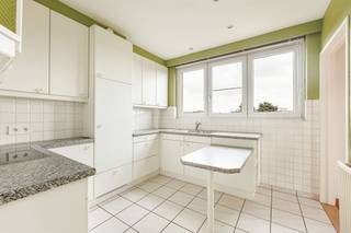 <p><span> </span></p><p><span>Veel ruimte, veel licht en een vrij uitzicht: dit appartement van ca.129 m² op de vierde verdieping heeft het allemaal. Je krijgt een royale leefruimte van ca. 37 m², drie volwaardige slaapkamers, verrassend veel bergruimte én een rustige ligging vlak bij het Rivierenhof. Extra interessant: de garagebox met eigen oprit dient mee aangekocht te worden voor € 30.000.</span></p><p><span> </span></p><p><span>Licht langs alle kanten</span></p><p><span>Je neemt de lift naar de vierde verdieping en komt binnen in een ruime inkomhal. Een aparte vestiairehoek zorgt ervoor dat jassen, schoenen en tassen meteen een vaste plek hebben. Daarnaast zijn er in de hal nog twee aparte bergingen. </span></p><p><span>Via de deur met glas stap je de leefruimte binnen, en die is met z’n ca. 37 m² lekker royaal. De hoekligging en de vele ramen zorgen hier voor een zee aan natuurlijk licht en een mooi, open zicht. Dankzij de zuidoriëntatie is dit een bijzonder aangename plek voor een grote zithoek én eettafel. De vinyl visgraatvloer geeft de ruimte extra warmte.</span></p><p><span>De aparte keuken sluit rechtstreeks aan op de woonkamer en heeft een betegelde vloer, veel kastruimte, een werkblad met natuursteenlook, elektrisch vuur, oven, koelkast en dubbele inox spoelbak. Wie droomt van een hedendaagse open leefkeuken, kan hier ook de mogelijkheden bekijken om keuken en woonkamer meer met elkaar te verbinden.</span></p><p><span> </span></p><p><span>Drie échte slaapkamers & veel bergruimte</span></p><p><span>De drie slaapkamers liggen samen aan de andere kant van het appartement. En volwaardig mag je hier gerust letterlijk nemen: ze meten ca. 17,6 m², 19 m² en 12 m². Grote ramen trekken ook hier veel daglicht naar binnen, terwijl de ligging achteraan voor een fijne scheiding tussen leef- en slaapgedeelte zorgt.</span></p><p><span>De betegelde badkamer is praktisch ingericht met een douchecabine, hangtoilet, lavabo met meubel en spiegel, extra kastruimte en aansluiting voor de wasmachine. Nog meer spullen kwijt? Beneden beschik je over een ruime, droge privéberging.</span></p><p><span> </span></p><p><span>Ook technisch zit de basis goed, met pvc-ramen met dubbele beglazing, gevelisolatie, een gunstig EPC en een asbestveilige attestering. Het dak is volgens de aangeleverde info conform de doelstelling voor 2050.</span></p><p><span> </span></p><p><span>Groen wonen met alles vlakbij</span></p><p><span>Je woont hier aan de Collegelaan in een rustige, residentiële buurt met heel wat gezinnen. Het Rivierenhof ligt vlakbij: ideaal voor een wandeling, een rondje lopen of gewoon wat groen wanneer je daar zin in hebt. Voor de dagelijkse boodschappen hoef je evenmin ver en ook de bereikbaarheid is handig, met tram en bus in de buurt, een Velo-station op zo’n 300 meter en de Ring vlakbij.</span></p><p><span>De garagebox met oprit dient mee aangekocht te worden voor € 30.000.</span></p><p><span> </span></p>