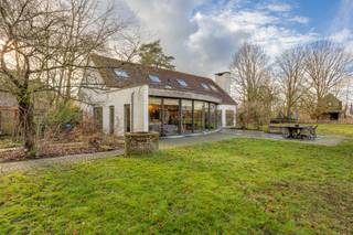 <p>Gelegen op een perceel van ca. 11.000 m² in bevindt zich deze hoeve met weiland en stallen aan de rand van Zoerselbos.<br />De woning combineert authentieke elementen met hedendaags comfort en is onder andere geschikt voor paardenliefhebbers. <br />Absolute rust, privacy en een uniek panoramisch vrij uitzicht zijn enkele troeven van dit eigendom.</p>
<p><strong><span>Hoofdgebouw</span></strong></p>
<p>Inkomhal met gastentoilet en vestiaireruimte - grote leefruimte met veel natuurlijke lichtinval ingedeeld in een zithoek open tot in de nok van het dak en voorzien van een O.H., een tv salon, eetkamer en een zeer ruime open en volledig geïnstalleerde keuken. De keuken is maatwerk en voorzien van Amerikaanse koelkast, een aanrecht en een groot kookeiland met zitruimte voorzien van een werkblad in Belgische blauwe natuursteen, ruime spoelbak - extra groot gasfornuis met 6 pitten, dubbele oven en dubbele dampkap. Aansluitend is er een berging en toegang tot de kelder.<br />Zowel vanuit de zithoek als de keuken is er via grote raampartijen zicht en toegang tot het terras en de tuin.</p>
<p>Op het gelijkvloers bevindt zich de hoofdslaapkamer met houtkachel. De ensuite badkamer is uitgerust met een ligbad, dubbele lavabo, inloopdouche en toilet. Daarnaast is er een aparte dressing. Via het schuifraam is er toegang tot het terras in bankirai.</p>
<p><span><strong>Verdieping</strong></span></p>
<p>De mezzanine staat in verbinding met de woonkamer. Een home office met zicht op de tuin is hier perfect mogelijk.</p>
<p>Op deze verdieping bevinden zich verder twee ruime slaapkamers. De badkamer is voorzien van een ligbad, lavabo en toilet. De plafonds reiken tot in de nok wat zorgt voor een ruimtelijk gevoel.</p>
<p><span><strong>Kelder</strong></span></p>
<p>De kelder van 28 m² biedt extra bergruimte.</p>
<p><span><strong>Buitenruimte en paardenfaciliteiten</strong></span></p>
<p>Het achterliggende perceel biedt diverse mogelijkheden en beschikt over een stalling voor twee tot drie paarden.</p>
<p>Achter de boomgaard bevindt zich een ruime carport van 7m x 10,5m met extra garage.</p>
<p><span><strong>Bijgebouw</strong></span></p>
<p>Het bijgebouw van Heritage Buildings is voorzien van een haard en kan dienen als ontspanningsruimte, lounge, hobbyruimte of werkplek.</p>
<p><span><strong>Bijzonderheden</strong></span></p>
<p>Vloerverwarming op aardgas (glvl) en combinatie verwarming/airco op verdieping (radiatoren mogelijk) - raamwerk in hout en aluminium - dubbele beglazing - overal massieve eiken plankenvloer - EPC 232 kWh/m² - UC 20250819-0003666936-RES-1 - elektriciteit niet conform - woning is asbestvrij - Vg-Ag-Gvv-Gvkr-Gmo-Gworg.</p>