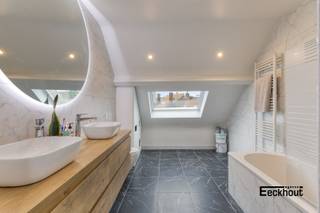 Deze energiezuinige rijwoning (EPC A) bevindt zich op slechts enkele passen van diverse winkels en supermarkten, invalswegen, scholen en bushaltes. Het strand ligt op nog geen kilometer van de woning en het centrum is te bereiken op 5 minuten fietsen.<br />Het huis onderging reeds grote renovatiewerken: het dak werd volledig vernieuwd (inclusief nieuwe isolatie), de muren werden geïsoleerd, de elektriciteit werd vernieuwd (conforme keuring), de ramen werden vernieuwd (driedubbel en HR-beglazing),....<br />Indeling: <br />- op het gelijkvloers: inkomhal, diepe berging (ideaal voor fietsen), woonkamer, aparte keuken, badkamer met ligbad, lavabomeubel, toilet en aansluiting voor wasmachine, zonnige (zuidwestoriëntatie) koer met aansluitende berging;<br />- op de eerste verdieping: nachthal, 2 grote slaapkamers;<br />- op de tweede verdieping: 3e grote slaapkamer met aansluitende badkamer (zeer recent vernieuwd) voorzien van een toilet, dubbel lavabomeubel en bad met douchescherm.<br />Er zijn elektrisch bedienbare rolluiken aanwezig aan de woonkamer en de slaapkamers. Er zijn 10 zonnepanelen aanwezig.<br />Mits enkele opfriswerken maakt u van deze woning een ware parel!