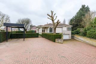 Prachtige woning met mooie privétuin en aansluitend weiland met een totale perceel oppervlakte van 5.908 m². De woning beschikt over een inkomhal met gastentoilet en vestiairekasten, ruime woonkamer (60 m²) met aansluitend zonneterras, ingerichte keuken, 2 slaapkamers, 2 badkamers, wasplaats en dubbele inpandige garage.<br /><br />Prachtige tuin met aanpalend weiland. Ideaal voor de dierenliefhebber!<br /><br />Indeling:<br />U betreedt de woning via de inkomhal met gastentoilet en inbouwkasten. Van hieruit heeft u toegang tot alle leefruimten. Aan de rechterzijde bevindt zich de ingerichte keuken met zicht op de voortuin en voorzien van alle comfort (keramische kookplaat, dampkap, vaatwasser, combi-oven en Amerikaanse koelkast met koel/vriescombinatie). Aansluitend treft u nog een praktische berging. Aan de linkerzijde geeft de inkomhal toegang tot de woonkamer dewelke zeer ruim en licht is en een prachtig zicht biedt op de tuin achteraan. De woonkamer heeft hoge plafonds en een gezellige inbouwgashaard. De tuindeuren bieden toegang tot het zonovergoten terras rondom de woning.<br /><br />Op de verdieping bevinden zich 2 slaapkamers, 2 badkamers en de wasplaats voorzien van inbouwkasten en aansluitingen voor wasmachine en droogkast. De masterbedroom beschikt over een ruime kastenwand met spiegels met aansluitend de ingerichte badkamer (ligbad, douche, toilet en dubbele wastafel). De tweede slaapkamer beschikt over een douchekamer (douche, enkele wastafel en toilet).<br /><br />In de kelderverdieping bevindt zich de dubbele inpandige garage, diverse opbergkasten en de CV-ruimte. <br /><br />Prachtige, onder architectuur aangelegde parktuin voorzien van diverse terrassen en een beregeningsinstallatie. Verder nog een mooi, volledig omheind weiland. <br /><br />Bijzonderheden:<br />-Automatische poort vooraan perceel<br />-Privé parkeerplaatsen + carport<br />-Hoogwaardige materialen gebruikt (o.a. eiken parket vloeren)<br />-Verwarming op aardgas<br />-Alarm aanwezig<br />-Airco aanwezig in de woonkamer