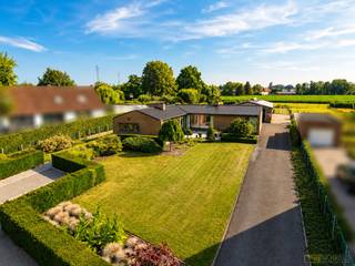 PERFECT ONDERHOUDEN BUNGALOW, gelegen op een UITERST RUSTIGE en LANDELIJKE LOCATIE met ZICHT OP DE KOPPENBERG. Deze LAAGBOUWVILLA werd in 1988 GRONDIG GERENOVEERD en sindsdien PIEKFIJN ONDERHOUDEN OOK. Gelegen op een UITGESTREKT PERCEEL van ca. 4.279 m², combineert deze eigendom COMFORTABEL WONEN met een UITZONDERLIJKE BUITENRUIMTE en TAL VAN MOGELIJKHEDEN voor ZELFSTANDIGEN, HOBBYISTEN of DIERENLIEFHEBBERS. Een ABSOLUTE MEERWAARDE is de combinatie van een INSTAPKLARE WONING, een RUIME LOODS van ca. 230 m², een VERWARMD ZWEMBAD (40m²), een SFEERVOLLE VIJVER en VERSCHILLENDE WEIDES, waardoor deze eigendom zich perfect leent voor wonen in combinatie met OPSLAG, een ZELFSTANDIGE ACTIVITEIT ,...<br />De indeling gaat als volgt: via de inkomhal heeft u toegang tot een gastentoilet en een 1ste slaapkamer of bureauruimte. Verder betreedt u de ruime woonkamer, die naadloos aansluit op een lichtrijke veranda (voorzien van airco ) met prachtig uitzicht op de tuin. Aansluitend treft men de ingerichte keuken, een 2de en 3de slaapkamer, een ingerichte badkamer, een praktische wasplaats, een 2de inkom en een ruime kelder die extra opslagmogelijkheden biedt.<br />Buitenshuis geniet u van een brede oprit tot aan het magazijn en nog 2 afzonderlijke parkeerplaatsen vooraan. Achteraan bevindt zich de veelzijdige loods, uitgerust met een koelcel, stallingsruimte en een aparte doucheruimte. De fraai aangelegde tuin met verwarmd zwembad en buitendouche, vijver en uitgestrekte weides maakt het plaatje compleet en biedt een uitzonderlijke woonbeleving in alle rust.<br />Bijzondere troef!: Zeer lage elektriciteitsfacturen door de aanwezigheid van 38 zonnepanelen. Een recente thuisbatterij van BYD en nieuwe hybride omvormer met energie management systeem van SMA!<br /><br />Adres: Schapendries 99 te Leupegem (Oudenaarde)<br /><br />EPC: in aanvraag, G-score en P-score D; Geen renovatieverplichting van toepassing; Bestuursmaatregelen in het maatregelenregister: Neen; Beschikbaarheid te bespreken met eigenaar