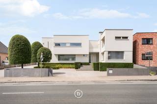 This detached, contemporary villa is situated on a spacious plot of over 1,500 m² and combines generous living spaces with a fully equipped, separate professional area. Thanks to its private entrance and air conditioning, this area can be used completely independently from the private section. This zone was originally set up as a dental practice and, due to its flexible layout, is ideal for a liberal profession, practice, consultancy, or office activity.<br /><br />The property originally dates back to 1975 and was thoroughly renovated in 2004, with a focus on comfort, functionality, and technical equipment. A living area of approximately 510 m², a well-thought-out layout, and seamless connection between the living spaces and the garden create a pleasant living experience. The high-quality Obumex kitchen is a refined and qualitatively finished part of the interior.<br /><br />A special feature of the property is the well-maintained and beautifully landscaped outdoor spaces. The heated swimming pool, sunny terraces, and fully equipped pool house with sauna, shower, and toilet create a distinct holiday feeling in the private garden. The integrated sound system on the ground floor, terrace, and in the pool house enhances this relaxed atmosphere.<br /><br />The villa is also technically well-equipped, with gas heating, a solar boiler, a heat pump for the pool, air conditioning in the master bedroom, and a central vacuum system.<br /><br />Adjacent to the property is a double garage, accessible via the driveway at the front. A second garage for one car is accessible via the rear street and provides a particularly practical additional entrance. There is also ample parking available at the front and rear.<br /><br />In short, a spacious and comfortable property where living, relaxing, and professional use come together in a natural way.