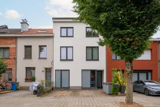 We komen in de woning via een ruimte inkomhal die naadloos overgaat in een zeer ruime living met open keuken.Grote raampartijen zorgen voor een open en warme sfeer. De leefruimte vloeit naadloos over in de prachtige, bloemrijke tuin met zonnig terras, een ideale plek voor ontspanning, gezellige diners en lange zomeravonden. De open keuken sluit perfect aan bij de leefruimte en is uitgerust met alle nodige toestellen. Dankzij de vlotte verbinding tussen keuken, eetplaats en zithoek ontstaat een aangename, huiselijke flow.-Eveneens op het gelijkvloers bevinden zich nog een ruime bureauruimte (ideaal voor thuiswerk) en een praktische wasplaats. Deze ruimte kan eveneens dienst doen als slaapkamer op het gelijkvloers, of als praktijkruimte met een aparte inkom.Een toilet en de toegang tot de zeer ruime kelder is toegankelijk via de leefruimte.Op de eerste verdieping zijn er twee grote slaapkamers, een grote dressing en een volledig uitgeruste badkamer. Op de tweede verdieping, die momenteel volledig is ingericht als zelfstandige wooneenheid, zijn er nog eens 3 slaapkamers, een keuken en een badkamer.Door het weghalen van 1 gyproc wand kan dit eenvoudig toegevoegd worden aan de rest van de woning. In totaal beschikt de volledige woning dus over minimum 5 slaapkamers, 2 badkamers, een praktijkruimte/bureau, en een oprit voor 2 auto's.Deze residentiële buurt staat bekend om haar rustige, familiale karakter en aangename leefomgeving, met scholen, winkels, parken en openbaar vervoer op korte afstand, en een vlotte verbinding naar de stad. Deze woning combineert hedendaags comfort met duurzaamheid dankzij een uitstekende energiescore A, 18 zonnepanelen en geavanceerde domoticasturing. Hier geniet je van modern wonen met lage energiekosten en optimaal gebruiksgemak. Door de vele mogelijkheden met de woning is dit een geschikt pand voor een groot gezin, een woning met de mogelijkheid om een gedeelte als zorgwoning te gebruiken, of mensen die een zelfstandige activiteit aan huis willen uitvoeren.Kortom zeker een bezoek waard.Graag een bezoek inplannen?☎️ 0472 74 03 15✉️ wim@lefevervastgoed.beWeergegeven oppervlakte is overgenomen van het EPC en louter indicatief.