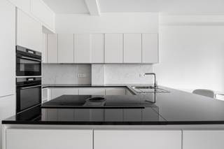 <p><span><strong>Instapklaar appartement op toplocatie in Antwerpen!<br /></strong><br /><strong>Op een centrale locatie aan de Italiëlei, tussen de Antwerpse binnenstad en het Eilandje, bevindt zich dit lichtrijke en instapklare appartement. De Universiteit Antwerpen, de Meir, winkels, restaurants en gezellige cafés liggen op wandelafstand. Dankzij de tram- en bushaltes voor de deur geniet u bovendien van een uitstekende bereikbaarheid.</strong></span></p>
<p><span>Het appartement is gelegen op de vijfde verdieping en werd in 2020-2021 gerenoveerd. </span></p>
<p><span>U komt binnen in een verzorgde inkom met ingemaakte kasten en een afzonderlijk gastentoilet. Aansluitend bevindt zich de volledig uitgeruste open keuken, voorzien van een kookeiland met inductiekookplaat, ingebouwde oven, microgolfoven en ruime opbergmogelijkheden.</span></p>
<p><span>De keuken gaat over tot de lichte leefruimte. Dankzij de grote ramen geniet deze ruimte van veel natuurlijk licht en een mooi, open uitzicht over de stad.</span></p>
<p><span>Aan de rustige achterzijde ligt de ruime slaapkamer, eveneens voorzien van ingemaakte kasten. De ensuite badkamer is afgewerkt met marmerlook wandtegels en beschikt over een ligbad met douchewand, een lavabo en ruimte voor een wasmachine. Vanuit de badkamer is er toegang tot een compact terras van circa 1 m².</span></p>
<p><span>Verder beschikt het appartement over een private kelderberging en is er een gemeenschappelijke fietsenstalling in het gebouw.</span></p>
<h3><em>Bijzonderheden</em></h3>
<ul>
<li><span>Gelegen op de vijfde verdieping;</span></li>
<li><span>Lichtrijke leefruimte met panoramisch stadszicht;</span></li>
<li><span>Afzonderlijk gastentoilet;</span></li>
<li><span>Compact terras van circa 1 m²;</span></li>
<li><span>EPC-label C: 251 kWh/(m² jaar);</span></li>
<li><span>Lift aanwezig;</span></li>
<li><span>Uitstekend bereikbaar met het openbaar vervoer;</span></li>
<li><span>Gemeenschappelijke kosten: circa € 155 per maand (water- en gasverbruik, lift, syndicus, blokpolis...)</span></li>
</ul>