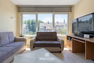 Voor meer info en foto’s, surf naar www.swevers.be – Dit te renoveren appartement op de eerste verdieping aan de Koolmijnlaan 45 in Houthalen biedt een bewoonbare oppervlakte van 81 m² en vormt een interessante opportuniteit voor wie graag een woning volledig naar eigen smaak wil vernieuwen. Het appartement dateert van 1965 en beschikt over een praktische indeling met twee slaapkamers, een aparte keuken, een ruime leefruimte en een inpandige garage. Via de centrale inkomhal bereik je alle vertrekken op een logische en overzichtelijke manier. De living van 22,80 m² geniet van veel natuurlijke lichtinval dankzij de grote raampartij en biedt voldoende ruimte voor een comfortabele zithoek en eetplaats. Aansluitend bevindt zich de aparte keuken van 11,21 m², waar je alle mogelijkheden hebt om een hedendaagse en functionele keuken te realiseren. Verder zijn er twee volwaardige slaapkamers van respectievelijk 12,60 m² en 13,30 m². De tweede kamer kan naast slaapkamer ook perfect ingericht worden als bureau, hobbyruimte of logeerkamer. De badkamer is uitgerust met een douche, lavabo en toilet en kan volledig worden aangepast aan de huidige woonnormen. De inpandige garage zorgt voor extra comfort en biedt plaats voor een wagen of bijkomende bergruimte. Dankzij de centrale ligging bevinden openbaar vervoer, winkels, restaurants en ontspanningsmogelijkheden zich op wandelafstand. Ook de snelweg ligt op minder dan één kilometer, wat zorgt voor een vlotte verbinding naar omliggende gemeenten. Dit appartement combineert een gunstige ligging met een duidelijke basis en veel renovatiepotentieel. Een ideale kans voor wie op zoek is naar een betaalbaar project dat volledig naar eigen wensen kan worden ingericht. Voor meer informatie, bel 011 255 155. Bron bewoonbare oppervlakte: EPC – verslag.