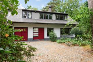 Gelegen in een van de meest gegeerde lanen van 's-Gravenwezel geniet deze villa van een residentiële ligging, omringd door groen en rust. Het centrum van 's-Gravenwezel, scholen, winkels, horeca en openbaar vervoer bevinden zich op korte afstand, terwijl de vlotte verbinding naar Schilde, Brasschaat en Antwerpen zorgt voor een uitstekende bereikbaarheid. Hier woont u in een aangename en groene omgeving waar ruimte, privacy en wooncomfort centraal staan.<br /><br /><strong>Indeling</strong><br />Via de ruime oprit met voldoende parkeergelegenheid bereikt u deze uitstekend onderhouden villa.<br />De inkomhal met vestiairegedeelte en gastentoilet verwelkomt u in de woning en biedt toegang tot zowel de leefruimtes als de keuken.<br /><br />De ruime woon- en eetkamer vormen samen met de veranda één harmonieus geheel. Dankzij de grote raampartijen geniet u hier van een panoramisch uitzicht op de prachtig aangelegde tuin en het ruime terras, waardoor binnen en buiten naadloos in elkaar overvloeien.<br /><br />Aansluitend bevindt zich de uitgeruste keuken, voorzien van alle nodige toestellen en een mooi zicht op de tuin.<br />Via de keuken bereikt u een polyvalente ruimte, die zich perfect leent als bureau, speelkamer, hobbyruimte of extra slaapkamer. Daarnaast heeft u toegang tot de inpandige garage met berging, waar zich tevens de aansluitingen voor wasmachine en droogkast bevinden.<br /><br /><strong>Verdieping</strong><br />Op de eerste verdieping bevinden zich drie volwaardige slaapkamers en een vierde kamer, die ingericht kan worden als slaapkamer, bureau of dressing. Vanuit deze kamer bereikt u via een mezzanine de praktische opbergzolder.<br /><br />De badkamer is uitgerust met een ligbad, douche, dubbele lavabo en toilet.<br /><br /><strong>Tuin</strong><br />De fraai aangelegde tuin vormt zonder twijfel één van de grootste troeven van deze woning. Dankzij de doordachte inrichting, de verschillende zitplaatsen in de tuin en de gevarieerde beplanting geniet u hier op elk moment van de dag van rust, privacy en een bijzonder aangename buitenbeleving.<br /><br />Tot slot beschikt de woning nog over een kruipruimte en een wijnkelder, bereikbaar via de garage.<br /><br /><strong>Bijzonderheden:</strong><br />+ Topligging<br />+ Prachtig aangelegde tuin<br />+ Polyvalente ruimte op het gelijkvloers<br />+ EPC: D (geen renovatieverplichting)<br />+ Natuurleien