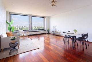 Dit appartement is gelegen in de rustige en residentiële Esmoreitlaan op Linkeroever, in de Habitim Tower. Vanuit deze locatie woont u in een groene omgeving, maar toch vlak bij het centrum van Antwerpen. De Schelde, de wandeldijk en het Sint-Annastrand bevinden zich op wandelafstand, ideaal voor een ontspannende wandeling of fietstocht. Ook winkels, scholen en openbaar vervoer zijn vlot bereikbaar. De hoge ligging van het appartement zorgt daarnaast voor een prachtig uitzicht over de Schelde en de skyline van Antwerpen. Dit aangename appartement bevindt zich op de twaalfde verdieping van de Habitim Tower. De ruime leefruimte van 33 m² is afgewerkt met een parketvloer en geniet dankzij de grote raampartijen van een aangename lichtinval. De keuken sluit aan op de leefruimte en is uitgerust met de nodige toestellen. Het appartement beschikt over twee slaapkamers van respectievelijk 16,5 m² en 10 m², beide voorzien van een laminaatvloer. Vanuit beide slaapkamers heeft u toegang tot het ruime terras van 13,5 m². Dankzij de elektrische zonneluifel kunt u hier op zonnige dagen aangenaam vertoeven en volop genieten van het prachtige uitzicht. De badkamer beschikt over een ligbad en een dubbele lavabo. Het toilet is apart en voorzien van een handenwasser. Daarnaast beschikt het appartement over een privatieve kelderberging, ideaal als extra opbergruimte.