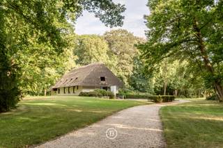 Midden in de prachtige bossen van Hertsberge, bereikbaar via een lange private oprijlaan vanaf de Toekomststraat, bevindt zich dit uitzonderlijke landgoed op een perceel van 19.110 m². Een unieke plek waar rust, privacy en natuur in perfecte harmonie samenkomen.<br /><br />Centraal op het domein staat een karaktervolle villa met authentiek strooien dak en een royale bewoonbare oppervlakte van 510 m². De woning vormt de ideale basis voor een totaalrenovatie, waarbij authenticiteit en hedendaags wooncomfort kunnen samensmelten tot een exclusieve droomresidentie.<br /><br />Het omliggende park werd recent volledig heraangelegd en beschikt over een rijke variatie aan inheemse bomen, een idyllische vijver en een privétennisterrein. Een ware oase van rust en privacy, ideaal voor wie op zoek is naar een uitzonderlijke woonbeleving midden in het groen.<br /><br />De bestaande villa kan worden vervangen door een nieuwe residentiële villa met een bouwplaat tot maar liefst 1.500 m². Wenst u nog meer ruimte en mogelijkheden, dan kan het domein worden uitgebreid tot ongeveer 2,8 hectare, inclusief twee exclusieve bouwgronden.<br /><br />De indrukwekkende oprijlaan, de bijzondere architectuur en de unieke setting maken van deze eigendom een zeldzame opportuniteit voor wie op zoek is naar een prestigieuze woonomgeving waar natuur, ruimte en exclusiviteit elkaar moeiteloos ontmoeten.