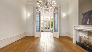 Bij het betreden van deze statige woning naar de hand van architect Jules Taeymans word je meteen verwelkomd in een indrukwekkende inkomhal die naadloos overgaat in een karaktervolle traphal. Op deze verdieping bevinden zich een recent vernieuwde keuken (Interieurstudio Hoskens), een sfeervol salon met hoge plafonds en verfijnde ornamenten, een ruime eetkamer en een lichtrijke tuinkamer die uitkijkt op de tuin.<br /><br />Daarnaast is er een polyvalente hobby- of kantoorruimte met apart sanitair en sauna, rechtstreeks toegankelijk via de inkomhal – ideaal voor ontspanning of professioneel gebruik. Aansluitend vind je de technische ruimte met o.a. de omvormer van de zonnepanelen en de centrale verwarming.<br /><br />Buiten geniet je van een zonnig terras, een gezellige stadstuin en rechtstreekse toegang tot de dubbele garage.<br /><br />Op de verdiepingen bevinden zich maar liefst 7 volwaardige slaapkamers met houten vloeren en 2 badkamers. Deze woning leent zich perfect voor grote gezinnen, co-housing, een combinatie van wonen en werken, of voor wie ruim en comfortabel in het hart van de stad wil wonen.<br /><br />Deze unieke herenwoning biedt uitzonderlijk veel mogelijkheden, zowel voor privébewoning als voor de inrichting van een kantoor of praktijkruimte.<br /><br />Buitengewone troeven:<br />* Tijdloze architectuur gecombineerd met hedendaags comfort, inclusief een dubbele garage met uitrit naar de Molenstraat – een absolute meerwaarde in deze buurt<br />* Energiezuinig dankzij zonnepanelen (2010), conforme elektrische keuring en quasi asbestvrij (enkel één radiatorknop in een slaapkamer)<br />* Centrale ligging nabij winkels, horeca en openbaar vervoer