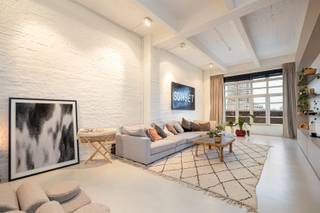 <p>Deze indrukwekkende loft van maar liefst 325 m², met terras en binnentuin, is een zeldzame vondst in het hart van Antwerpen — op een steenworp van Park Spoor Noord en het Eilandje.</p><p>De voormalige pakhuizen van de Van de Wervestraat ademen geschiedenis, maar binnenin wacht pure moderniteit. Denk aan hoge plafonds, massieve draagstructuren en overvloedig daglicht, gecombineerd met tijdloze materialen en doordacht design.<br />Hier woon je in een bruisende buurt vol creatieve energie — tussen kunstgalerijen, hippe horeca en vernieuwde stadspleinen. Alles wat het Antwerpse stadsleven zo boeiend maakt, ligt letterlijk aan je voeten.</p><p>Waarom je hier wil wonen<br />• Uitzonderlijke loft van 325 m²<br />• Terras én gemeenschappelijke binnentuin<br />• Designinterieur met maatwerk en hoogwaardige materialen<br />• Open leefruimte met imposante plafondhoogte en veel licht<br />• Mogelijkheid tot ruime inpandige autostaanplaats (€55.000)</p><p>Bij het binnenkomen zet de hoge plafonds en het overvloedige licht meteen de toon.</p><p>De inkomhal met vestiairekast en gastentoilet leidt naar een tweede slaapkamer — perfect als gastenkamer of kantoor.</p><p>De royale leefruimte vormt het hart van de loft: open, warm en gelaagd.<br />De open keuken is een statement van klasse: natuurstenen werkblad, kamerhoge fineerkasten en hoogwaardige toestellen. De leefruimte geeft toegang tot het terras, vanwaar je uitkijkt op de groene binnentuin — een oase midden in de stad.</p><p>Een subtiele kastenwand scheidt de leefruimte van de master suite en creëert rust en privacy. De master beschikt over een dressing, een luxueuze badkamer met vrijstaand bad, dubbele wastafel en inloopdouche — hotelgevoel inbegrepen.</p><p>Deze loft is niet zomaar een woonst, het is een beleving.<br />Ruimte, licht en verfijning in één strak geheel, met respect voor het industriële karakter van het gebouw.</p><p>Ontdek deze exclusieve loft en plan je bezoek via sinjoor.be.</p><p><span><span> </span></span></p>
