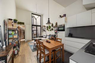 <p><span>Op zoek naar een tof appartement midden in de stad? Hier krijg je een lichte leefruimte met hoge plafonds, een gezellige stadskoer, een achteraan gelegen slaapkamer én een extra bureel op een extra verdieping. De warme parketvloer, nette afwerking en ligging vlak bij de Ossenmarkt krijg je er zo bij!</span></p><p><span>Veel licht, hoge plafonds & parket</span></p><p><span>Je komt binnen in de leefruimte met open keuken, waar de hoge plafonds (4.20m!) meteen voor een fijn ruimtegevoel zorgen. De mooie parketvloer loopt door in de zithoek en maakt het geheel warm en gezellig. Dankzij de hoge ramen valt er bovendien lekker veel daglicht binnen.</span></p><p><span>De witte keuken is strak en praktisch ingericht, met veel kastruimte, een grijs en ruim werkblad, spoelbak, kookplaat en ingebouwde oven. Er is plaats voor een eettafel vlakbij de keuken, terwijl je aan de andere kant makkelijk een ruime zithoek installeert. Een fijne open leefplek dus, zonder dat keuken en salon in elkaars weg zitten.</span></p><p><span>Vanuit de leefruimte stap je rechtstreeks de stadskoer op. Met een tafel, wat stoelen en groen maak je hier een gezellige buitenplek waar je bij mooi weer heerlijk buiten kunt eten.</span></p><p><span>Via de hal wandel je naar het gastentoilet, de slaapkamer en de badkamer. De slaapkamer ligt rustig achteraan en heeft dezelfde warme parketvloer. Extra leuk: ook van hieruit heb je rechtstreeks toegang tot de stadskoer.</span></p><p><span>De badkamer is strak afgewerkt met een grote inloopdouche, een dubbel lavabomeubel in houtlook en een grote spiegelkast. Alles wat je nodig hebt, zonder overbodige franjes. Ideaal!</span></p><p><span>Een verdieping extra</span></p><p><span>De houten spiltrap in de hal brengt je naar boven, waar je nog een verrassend grote extra ruimte hebt. Het aparte bureel is eveneens afgewerkt met parket, krijgt natuurlijk licht binnen en biedt meer dan genoeg plaats voor een fijne thuiswerkplek. Een hobbykamer, dressing of logeerplek kan hier natuurlijk evengoed.</span></p><p><span>Op de overloop is ook plaats voorzien voor de wasmachine, netjes uit de leefruimte. En spullen die je niet elke dag nodig hebt? Die kun je kwijt in de kelder. Voor de fiets is er een gemeenschappelijke fietsenstalling in het gebouw voorzien.</span></p><p><span>Midden in de stad </span></p><p><span>Je woont hier pal in het historische centrum van Antwerpen, vlak bij de gezellige Ossenmarkt en midden in de universiteitsbuurt. Terrasjes, restaurants, koffiebars en winkels heb je hier voor het uitkiezen, en ook de Paardenmarkt en Stadswaag liggen vlakbij. Voor tram en bus hoef je niet ver en ook het Centraal Station bereik je makkelijk te voet of met de fiets. Een echte stadsplek dus, met zowat alles binnen handbereik. </span></p><p><span> </span></p>