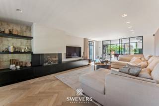 Voor meer info en foto’s, surf naar www.swevers.be – Welkom in de Keelstraat 94 in Sint-Truiden. Deze volledig gerenoveerde open bebouwing (2019) combineert het karakter van de oorspronkelijke woning uit 1976 met hedendaags comfort, hoogwaardige materialen en een luxueuze afwerking. Met een bewoonbare oppervlakte van 276 m² op een perceel van 28 are 50 centiare geniet u van ruimte, rust en een prachtig vrij uitzicht over het achterliggende agrarische gebied. De lichtrijke leefruimte sluit naadloos aan op de royale leefkeuken met kookeiland. Verder beschikt de woning over vier volwaardige slaapkamers, een stijlvolle badkamer, een dressing, een praktische wasberging en technische ruimte. Een aparte polyvalente ruimte met eigen inkom, toilet en keukentje biedt tal van mogelijkheden als praktijk, kantoor, studio of hobbyruimte. Dankzij de slaapkamer en badkamer op het gelijkvloers is ook gelijkvloers wonen perfect mogelijk. Buiten geniet u van een zuidgerichte tuin en ruim terras waar privacy en zon centraal staan. Domotica, airconditioning, alarmsysteem, videofoon, jacuzzi, zonnepanelen (ca. 4.000 kWh/jaar), maatwerk en een mindervalidentoegankelijke inrichting zorgen voor een uitzonderlijk wooncomfort. Bovendien zijn er ruime parkeermogelijkheden op eigen terrein. De rustige ligging wordt perfect aangevuld met een vlotte bereikbaarheid van scholen, winkels, horeca en ontspanning. Een ideale woning voor gezinnen of wie wonen en werken wil combineren. Voor meer informatie, bel 011 255 155. Bron bewoonbare oppervlakte: EPC – verslag.