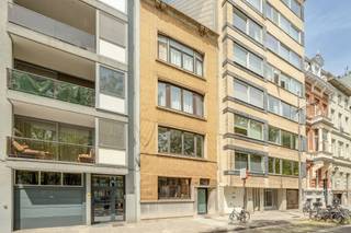 Dit ruime gelijkvloerse appartement bevindt zich op een toplocatie aan de Amerikalei, in een populaire en levendige buurt met winkels, horeca, openbaar vervoer en invalswegen binnen handbereik. De centrale ligging combineert stadscomfort met een vlotte bereikbaarheid.<br /><br />U komt binnen in een ruime inkomhal met toegang tot een bureauruimte die eveneens kan dienen als slaapkamer of leefruimte. De volledig geïnstalleerde keuken is uitgerust met een aansluitende wasplaats en geeft rechtstreeks toegang tot de stadstuin. In de gang vindt u een apart toilet en een ruime leefruimte die flexibel kan worden ingericht als living, extra slaapkamer of bureau. Achteraan ligt de rustige slaapkamer, naast de badkamer met inloopdouche. Een privatieve kelderberging biedt extra opbergruimte.<br /><br />De tuin vormt een aangename buitenruimte waar u in alle rust kunt genieten van het buitenleven midden in de stad.<br /><br />Met een EPC-label E valt het pand onder de renovatieverplichting. Dit pand is onderworpen aan de renovatieverplichting van de Vlaamse overheid voor residentiële gebouwen (behoudens bij sloop binnen 5 jaar na de aankoop). Consulteer voor meer informatie de website van het Vlaams Energie- en Klimaatagentschap via https://www.vlaanderen.be/een-huis-of-appartement-kopen/renovatieverplichting-voor-residentiele-gebouwen.<br /><br />Troeven<br />Toplocatie aan de populaire Amerikalei<br />oppervlakte van 137 m²<br />parketvloer<br />Flexibele indeling met bureau- of extra slaapmogelijkheid<br />Gezellige stadstuin <br />slaapkamer aan de achterzijde