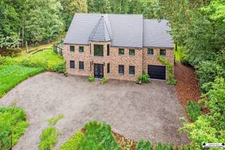 <p><span>Zeldzame nieuwbouwwoning op een perceel van 40 are met imposante tuin te Kapellen</span></p><p><span> </span></p><p><span> </span></p><p><span> </span></p><p><span> </span></p><p><span>Deze prachtig, beveiligde en energiezuinige, villa die hoogstaand is afgewerkt met perceelsoppervlakte van 40 are is gelegen in een groene omgeving aan de overkant van het natuurgebied  het ‘Groot Schietveld’ en op slechts een kleine 10 km van centrum Brasschaat. Door de smaakvolle kwalitatieve elementen is deze woning werkelijk uniek te noemen. Deze woning omvat maar liefst 5 of meerdere ruime slaapkamers, badkamer, grote dressing, bureauruimte, lichtrijke leefruimte met open keuken, grote bergruimte, wellness, inpandige garage en een volledig ingerichte 2de verdieping met extra opbergruimte. Deze woning biedt tal van mogelijkheden waardoor deze woonst geschikt is voor iedereen.</span></p><p><span> </span></p><p><span>Gelijkvloerse verdieping</span></p><p><span>De imposante inkomhal met glas in lood ramen vormt meteen dé eyecatcher van de woning. Deze ruimte verleent ook toegang tot de bureauruimte en de zithoek met prachtig uitzicht over de tuin. De open keuken is voorzien van alle comfort met talrijke kasten en schuiven. Alle noodzakelijke toestellen zijn aanwezig: vaatwasser, ijskast, inductie kookplaat met ingebouwde dampkap, spoelbak met Quooker-kraan. </span></p><p><span>Bovendien is de wellness-ruimte met sauna/infraroodcabine en inloopdouche toegankelijk via de open leefruimte.  </span></p><p><span>Via de bergruimte met ingemaakte kasten bereikt men de inpandige garage. Alle nutsvoorzieningen zijn mooi weggewerkt in de kasten.</span></p><p><span> </span></p><p><span>Eerste verdieping</span></p><p><span>De eerste verdieping, bereikbaar via een volle eiken trap is voorzien van 4 grote slaapkamers, dressing (of extra slaapkamer) en badkamer. </span></p><p><span>De badkamer is smaakvol ingericht en voorzien van een dubbele douche, ligbad, handdoekdroger en lavabomeubel. Ook vanuit deze ruimte wordt het prachtige uitzicht over de tuin benadrukt. </span></p><p><span> </span></p><p><span>Tweede verdieping</span></p><p><span>De tweede verdieping is volledig ingericht en fungeert als hobbykamer, gameroom en cinemakamer alsook nog extra bergruimte. </span></p><p><span>Deze verdieping leunt zich toe om iedere inrichting naar wens te maken.</span></p><p><span> </span></p><p><span>Tuin en overdekt terras</span></p><p><span>Aan de woning bevindt zich een overdekt terras waar je bij alle weersomstandigheden kan genieten van een prachtig uitzicht over de aangelegde tuin. </span></p><p><span>Ook de orangerie zorgt voor een eye-catcher in de tuin. Bijkomende zijn de faciliteiten voor een zwembad/zwemvijver ook voorzien. </span></p><p><span> </span></p><p><span>Bijzonderheden</span></p><p><span>Verkoop onder verkooprechten dus niet onder BTW</span></p><p><span>Energiezuinige woning: label A - E40</span></p><p><span>Ventilatiesysteem type D</span></p><p><span>Domoticasysteem: programmeerbare schakelaars</span></p><p><span>Rookmelders</span></p><p><span>Alarmsysteem en bewegingsdetectoren</span></p><p><span>Regenwaterput</span></p><p><span>Kruipruimte 1,2 meter</span></p><p><span> </span></p><p><span> </span></p><p><span> </span></p><p><span> </span></p><p><span> </span></p>