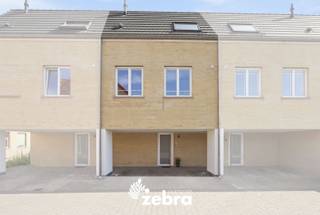 Deze lichtrijke bel-etage uit 2021 in Assebroek combineert een moderne indeling met een aangenaam terras, ruime ondergrondse garage en een schitterend E-peil. De woning werd professioneel en kwalitatief geschilderd en geniet een vlotte ligging nabij winkels, openbaar vervoer en het centrum van Brugge.<br /><br />Op het gelijkvloers komen we via de gemeenschappelijke parking binnen in de inkomhal, waar zich tevens een afzonderlijk gastentoilet bevindt en toegang tot de ondergrondse verdieping.<br /><br />De eerste verdieping vormt het hart van de woning. Hier bevindt zich de gezellige en lichtrijke leefruimte met zit- en eetgedeelte en een volledig uitgeruste open keuken. De grote raampartijen zorgen voor een bijzonder open gevoel en bieden een mooi zicht op het terras. Via het schuifraam, voorzien van een praktisch vliegenraam, krijgt u rechtstreeks toegang tot deze aangename buitenruimte.<br />De combinatie van de warme afwerking, de grote glaspartijen en de open keuken maakt dit tot een uitnodigende leefverdieping.<br /><br />Op de tweede verdieping bevinden zich drie slaapkamers en een badkamer uitgerust met wastafel, douche en toilet. Daarnaast is er een afzonderlijke wasruimte, waardoor ook deze verdieping bijzonder functioneel is ingericht.<br /><br />Een belangrijke extra troef is de combinatie van de ondergrondse berging en ruime garage die voorzien is van een manuele poort, verlichting en elektriciteit.<br /><br />Ook op technisch vlak heeft de woning heel wat te bieden, met onder meer zonnepanelen, een Renson C+ ventilatiesysteem, een waterontkalker en een regenwaterput.<br /><br />Buiten kunnen de bewoners gebruikmaken van de volledig omheinde gemeenschappelijke tuin, die gedeeld wordt met de andere bewoners.<br /><br />Een instapklare bel-etage met een doordachte indeling, veel licht, aangename buitenruimte en een ruime garage op een fijne ligging in Assebroek. Ideaal voor wie comfortabel en energiegericht wil wonen vlak bij Brugge.<br /><br />De vraagprijs is inclusief de op maat gemaakte raamdecoratie en zonwering. <br /><br /><strong>Ook wild geworden van deze thuis?<br />Twijfel dan niet langer en leg vandaag nog uw bezoek vast!</strong>