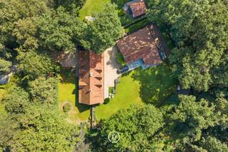 Deze vrijstaande villa bevindt zich in een woonpark op een bijzonder groene en bosrijke locatie nabij het Kraenepoel in Aalter. Met een bewoonbare oppervlakte van 314m² en een perceel van ongeveer 2.224 m² biedt deze eigendom een aangenaam gevoel van ruimte, privacy en rust.<br />De eigendom ligt in een doodlopende straat, dus extra veilig voor gezinnen met kinderen. <br /><br />De woning wordt omgeven door een verzorgd aangelegde tuin met terras, volwassen beplanting en toch voldoende inval van de zon. De gegeerde ligging nabij het Kraenepoel combineert een uitzonderlijk natuurlijk kader met een vlotte bereikbaarheid. <br /><br />De villa beschikt over houten schrijnwerk met dubbele beglazing en wordt verwarmd met een stookolieketel. Op energetisch vlak scoort de woning een EPC 'C', dus geen renovatieplicht, desondanks biedt de woning nog mogelijkheden tot verdere optimalisatie, onder meer wat betreft de isolatie van het dak.<br /><br />Een bijzondere meerwaarde vormt het ruime bijgebouw met atelier en opslagruimte. Deze ruimte leent zich uitstekend voor het stallen van oldtimers, het uitoefenen van een hobby of het creëren van een professionele werk- of opslagplaats. Daarnaast is er nog een afzonderlijk tuinhuis aanwezig.<br /><br />De eigendom beschikt over een eigen boorput voor de watervoorziening.