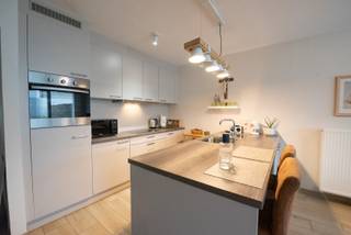 Gelijkvloers appartement met 2 slaapkamers, woonkamer met open keuken (voorzien van alle toestellen), ruime badkamer (douche/dubbele wastafel), berging, west-georiënteerd terras + tuin en inclusief garagebox.<br /><br />Onmiddellijk beschikbaar. <br />Syndickosten: €50/maand.<br /><br />Voor meer info of een bezoek: lisa@immoroba.be