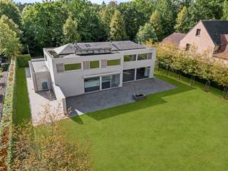 Dans un endroit particulièrement calme et résidentiel à Oud-Turnhout se trouve cette villa moderne, construite en 2014 et située sur un beau terrain de 1 750 m². La villa se distingue par son architecture épurée, ses généreux volumes de vie et son agencement réfléchi et particulièrement fonctionnel. De grandes baies vitrées offrent une abondance de lumière naturelle et renforcent la connexion entre les espaces de vie, les terrasses et le jardin. Avec quatre chambres à coucher complètes, deux salles de bains, un double garage intégré et un sous-sol complet, cette villa offre une sensation d'espace exceptionnelle et tout le confort pour une famille. Des aménagements sur mesure de haute qualité (réalisés par ILB à Kasterlee) parcourent la maison et lui confèrent une allure intemporelle et soignée. Sur le plan énergétique également, la villa convainc avec un label énergétique exceptionnel A et un score énergétique de seulement 94 kWh/m² par an.<br /><br />Rez-de-chaussée :<br />Le spacieux hall d'entrée avec vestiaire et toilettes invités forme une entrée agréable et donne accès aux différents espaces de vie. Au centre de la maison se trouve le généreux salon avec cheminée au gaz, qui, grâce à son agencement ouvert, se connecte parfaitement à la cuisine entièrement équipée. Les grandes baies vitrées offrent une agréable lumière naturelle et offrent une belle connexion avec le jardin et les vastes terrasses qui sont directement accessibles depuis le salon et la cuisine. La cuisine est équipée d'un plan de travail en Corian et d'une table à manger intégrée, et dispose d'un ensemble complet d'appareils électroménagers de qualité, dont une plaque à induction, un four à vapeur haute pression Miele, un four à chaleur tournante Miele, un réfrigérateur et un lave-vaisselle. <br />Adjacent au salon se trouve un espace bureau séparé avec bureau fixe et armoires sur mesure. Un endroit idéal pour le télétravail, l'étude ou un espace de travail paisible. Le rez-de-chaussée comprend également une buanderie spacieuse et pratique, ainsi qu'un garage double intégré avec place pour deux voitures et deux points de charge. Depuis le garage, il y a un accès direct au jardin ainsi qu'au sous-sol.<br /><br />Premier étage :<br />L'escalier depuis le hall d'entrée mène à un hall de nuit spacieux et lumineux. La suite parentale forme une zone privée complète et comprend une grande chambre à coucher, un dressing séparé et une salle de bains privative avec baignoire, douche, double vasque et toilettes. En outre, à cet étage se trouvent trois autres chambres à coucher complètes. Chacune de ces chambres est équipée de placards sur mesure pratiques et d'un bureau intégré, alliant ainsi fonctionnalité et esthétique. Une deuxième salle de bains avec douche et double vasque est à disposition de ces chambres. Le hall de nuit abrite également des toilettes séparées.<br /><br />Sous-sol :<br />Un atout particulier est le sous-sol complet de la villa. Outre une quantité exceptionnelle d'espace de rangement supplémentaire, cet étage offre de nombreuses possibilités pour une utilisation sur mesure, comme un espace hobby, une salle de fitness, une salle de jeux, une cave à vin ou un espace de stockage supplémentaire.<br /><br />Jardin & terrasses :<br />La villa est située sur un grand terrain de 1 750 m² et est entourée d'un vaste jardin qui crée un cadre verdoyant agréable et assure l'intimité nécessaire. L'ensemble est clôturé et équipé d'un portail automatique côté rue. Adjacents au salon et à la cuisine se trouvent de vastes terrasses, permettant ainsi aux espaces de vie de se prolonger naturellement à l'extérieur pendant les mois les plus chauds. La connexion directe entre la cuisine, le salon, les terrasses et le jardin rend l'ensemble particulièrement agréable à la fois pour la vie quotidienne de la famille et pour recevoir des invités.<br /><br />Confort de vie économe en énergie :