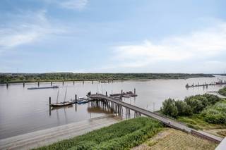 Droom jij van wakker worden met uitzicht op de Schelde, het omliggende groen én zelfs het Atomium aan de horizon?<br />In dit exclusieve appartement op de zevende verdieping van een verzorgd gebouw uit 2010 in Rupelmonde, wordt dit jouw dagelijkse realiteit.<br /><br />Bij binnenkomst verwelkomt de ruime inkomhal je met plafondhoge ingemaakte vestiairekasten, gastentoilet en sfeervolle nachthalverlichting.<br />De leefruimte baadt in natuurlijk licht dankzij de <strong>raampartijen</strong> en biedt een spectaculair zicht op het water en de skyline van Rupelmonde.<br />De open, kwalitatieve keuken met keukeneiland is volledig uitgerust en sluit aan op een praktische berging met opbergruimte.<br /><br />Het appartement beschikt over <strong>drie volwaardige slaapkamers</strong>, allen voorzien van parket en ingemaakte kasten. De master bedroom geniet bovendien van een ruime <strong>walk-in dressing</strong>.<br />Alle slaapkamers bieden rechtstreeks toegang tot het royale, <strong>zuidgerichte terras</strong> vanwaar je in alle rust en privacy van het prachtige uitzicht geniet.<br /><br />De badkamer is uitgerust met een dubbele lavabo, ligbad met douchemogelijkheid en een tweede toilet.<br />Automatische screens zorgen over het hele appartement voor comfort en privacy op maat.<br /><br /><strong>Extra troeven:</strong><br />Aluminium ramen met dubbel glas<br />Centrale verwarming op aardgas<br />Overal ingemaakte kasten<br />Elektrische zonnewering en automatische screens<br />Ondergrondse private kelderberging (6 m² – met elektriciteit) inbegrepen<br /><strong>Parkeren</strong>:<br />Een ondergrondse autostaanplaats – €25.000 en een ruime garagebox (3,10 m x 6 m) – €35.000, kunnen optioneel bij aangekocht worden.<br /><br />Bron bewoonbare oppervlakte : EPC - certificaat<br /><br />Ben je op zoek naar een luxueuze woonst met comfort, ruimte en een uitzicht dat élke dag weet te bekoren? Neem dan snel contact met ons op voor een bezoek!<br />Ben je ook van plan jouw eigendom te verkopen? Maak een afspraak voor een gratis schatting, wij maken er samen een succesverhaal van.