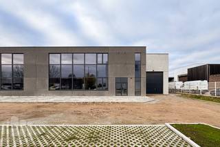 <strong>Nieuwbouw magazijn van 1.298 m² met 206 m² kantoorruimte en 218 m² polyvalente ruimte.</strong><br /><br />Het magazijn, op eigen perceel, is opgebouwd uit een staalconstructie met betonpanelen en een vloerbelasting van 3,5T/m². De magazijnruimte is toegankelijk via twee automatische sectionale poorten (4 m H X 4,5 m B) met afzonderlijke toegangsdeuren. Verder is de loods, met een vrije hoogte van +/- 6 m voorzien van een  lichtstraat met rookkoepel, polybetonvloer , sanitaire ruimte, kitchenette en de nodige verlichting.<br /><br />De polyvalente ruimte van 218 m² bevindt zich in de voorste ruimte op het gelijksvloer en is voorzien van de nodige nutsvoorzieningen en een lichtrijke dubbele opendraaiende voordeur met grote raampartijen. De kantoorruimte van 206 m² is uitgerust met alle nodige nutsvoorzieningen, telefonie en internet, kitchenette, verwarming.<br /><br />Deze combinatie van kantoorruimte en polyvalente ruimte zorgt ervoor dat de loods niet alleen functioneel is voor opslag of productie, maar ook voor diverse commerciële en zakelijke doeleinden. <strong>Ruime manoeuvreerruimte op de site met aanwezigheid van 22 parkeerplaatsen</strong>.  <strong>Zonnepanelensysteem </strong>op dak aanwezig.<br /><br /><strong>Onmiddellijk beschikbaar</strong> en verder in richten/af te werken naar eigen smaak.<br /><br />Contacteer <strong>PANORAMA B2B</strong> voor meer inlichtingen of een vrijblijvend plaatsbezoek op het nummer <strong>03 225 03 03</strong>.