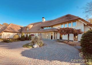 <p><strong>In de gegeerde residentiële verkaveling De Lint in Oud-Turnhout vinden we deze bijzonder ruime en charmante villa, ontworpen door architect Hertroijs. Een woning met klasse, warmte en een uitzonderlijke totaalbeleving—rustig wonen, maar toch centraal, op slechts 25 minuten van zowel Eindhoven als Antwerpen.</strong></p>
<p>De villa beschikt over een nieuwe rieten kap, goed voor decennialang zorgeloos wooncomfort. In de prachtig aangelegde tuin geniet u van een vernieuwd en verwarmd buitenzwembad en een sfeervolle vijver die het buitenleven een haast vakantiesfeer geven.<br />Bovendien is inruil van uw eigen woning mogelijk, wat de aankoop extra toegankelijk maakt.</p>
<p><span><strong>Indeling</strong></span><br />De ruime inkomhal vormt een stijlvolle entree, geeft uit naar het gastentoilet en de bureauruimte alsook naar de verschillende leefruimtes van de woning. De royale woonkamer baadt in natuurlijk licht en geniet dankzij grote raampartijen van een continu zicht op de tuin. De volledige gelijkvloerse verdieping is afgewerkt met een prachtige natuurstenen vloer in combinatie met vloerverwarming, wat zorgt voor een warm en luxueus wooncomfort.</p>
<p>De heerlijke leefkeuken, uitgerust met geïntegreerde eetkamer en een gezellige tv-hoek, vormt het hart van het huis. Aansluitend bevindt zich de praktische wasruimte met achterliggend een apart toilet en douche, ideaal voor zwembadgasten. Verder is er een inpandige garage voor twee wagens.</p>
<p>Op de verdieping bevinden zich vier slaapkamers, een afzonderlijke dressing en twee badkamers. De dressing werd oorspronkelijk als vijfde slaapkamer ingetekend en kan indien gewenst eenvoudig opnieuw als slaapkamer worden ingericht.<br />De hoofdslaapkamer beschikt over een ensuite luxe badkamer met ligbad, douche, toilet en dubbele wastafel. De tweede badkamer is gemeenschappelijk en bevindt zich aan de nachthal. Op deze verdieping werd deels gekozen voor een massief eiken parketvloer, wat de ruimtes een warme, tijdloze uitstraling geeft.</p>
<p><strong>Deze villa biedt een unieke combinatie van karakter, ruimte, luxe en natuurrust op een van de mooiste locaties van Oud-Turnhout. Een uitzonderlijke kans voor wie exclusief én comfortabel wil wonen.</strong></p>