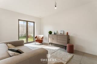 Voor meer info en foto’s, surf naar www.swevers.be – Dit recente gelijkvloerse appartement in residentie Oriole, gelegen in de Edward Stainstonstraat 4 A0.1 in Heusden-Zolder, combineert modern wooncomfort met een rustige ligging aan een natuurgebied. Het appartement werd gebouwd in 2024 en is volledig instapklaar afgewerkt met oog voor energiezuinigheid en praktisch wooncomfort.<br /><br />Met een bewoonbare oppervlakte van 129 m² beschikt het appartement over een ruime en doordachte indeling. De leefruimte van 23,85 m² sluit mooi aan op de open keuken van 18,75 m², waardoor een aangename en open woonomgeving ontstaat. Dankzij de grote raampartijen geniet u bovendien van veel natuurlijke lichtinval. Er zijn drie slaapkamers aanwezig van respectievelijk 13,07 m², 10,44 m² en 8,74 m². Deze ruimtes kunnen flexibel ingericht worden als slaapkamer, bureau of hobbyruimte. Verder zijn er twee badkamers voorzien, wat extra comfort biedt voor gezinnen of wie graag voldoende privacy heeft. Buiten geniet u van een terras van 16 m² met zuidoostelijke oriëntatie en een aansluitende tuin. Samen goed voor 44 m² buitenruimte waar u in alle rust kan ontspannen.<br /><br />Ook technisch scoort dit appartement uitstekend dankzij vloerverwarming, een eigen warmtepomp, zonnepanelen, ventilatiesysteem type D en superisolatie. Dit zorgt voor een aangenaam binnenklimaat en een lage energievraag. Verder is er een videofoon aanwezig. Het gebouw beschikt niet over een lift, kelderberging of staanplaats.<br /><br />De ligging combineert een groene en rustige omgeving met een vlotte bereikbaarheid. Winkels, horeca en ontspanning bevinden zich op wandelafstand. Scholen liggen op 800 meter, openbaar vervoer op 500 meter en de autosnelweg bereikt u op slechts 4,8 km.<br />Voor meer informatie, bel 011 255 155. Bron bewoonbare oppervlakte: EPC – verslag.