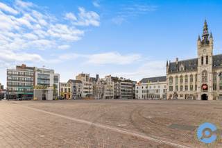 <strong>*** OPEN HUIS MOMENT - Donderdag 18 december tussen 11u en 14u ****</strong><br /><br />Instapklaar, recent gerenoveerd appartement op de eerste verdieping van een kleinschalig gebouw pal op de Markt van Sint-Niklaas.<br /><br />U komt binnen via een ruime inkomhal met apart gastentoilet en berging, waarna de open leefruimte meteen indruk maakt. Authentieke elementen zoals de visgraatparket en de marmeren sierschouw zijn behouden en krijgen extra cachet door de overvloedige lichtinval via de hoge raampartijen.<br />De halfopen, praktisch ingerichte keuken biedt alles wat u van een hedendaagse keuken verwacht en is afgewerkt met een gezellige ontbijt- en aperitiefbar zodat de kok nooit alleen is.<br />Achteraan liggen twee zeer ruime slaapkamers die uitgeven op een patio van circa 10 m², goed voor natuurlijke lichtinval en ventilatie.<br />De badkamer is uitgerust met dubbele wastafel, inloopdouche en toilet, en voorziet plaats voor wasmachine en droogkast.<br /><br />Extra pluspunten: renovatie met oog voor detail, gunstig EPC (label B), overal hoogrendementsbeglazing, conforme elektriciteit, asbestvrij, videofoon, aparte kelderberging en een gloednieuwe hoogrendementsketel.<br />Parkeren kan in de ondergrondse parking van de Grote Markt op abonnementsbasis.<br /><br />Vragen of een bezoek plannen na het bekijken van de foto’s en virtuele tour? Bel Nico via 0475/50 92 09.