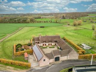 Te midden van het groene en glooiende landschap van Oosterzele bevindt zich deze uitzonderlijke vierkantshoeve met binnenkoer, paardenfaciliteiten...
