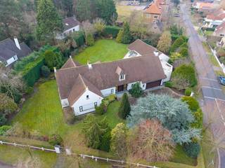 Dans la Veurnelaan à Saint-Idesbald, près des dunes de Houtsaeger, se trouve cette villa très spacieuse et élégante « Les Ramures », située dans un quartier résidentiel sur un terrain unique de pas moins de 2 749 m². Avec une surface habitable d'environ 676 m², cette propriété offre une combinaison exceptionnelle d'espace, de confort et d'intimité.<br />La villa vous accueille dans un hall d'entrée imposant avec vestiaire et toilettes séparées pour les invités. Le grand salon lumineux respire la classe et la chaleur et dispose d'une cheminée, d'un coin salon supplémentaire et d'une salle à manger donnant sur la cuisine semi-ouverte. Les matériaux utilisés, notamment les sols en travertin et les menuiseries en aluminium, soulignent le caractère haut de gamme et intemporel de la villa.<br />La villa compte quatre chambres très spacieuses, dont une chambre principale à l'étage avec dressing, salle de bains luxueuse et toilettes séparées. Il y a également trois chambres au rez-de-chaussée avec une salle de bains rénovée équipée d'une douche à l'italienne, double lavabo et de toilettes. En outre, la villa dispose d'un grand grenier qui offre de nombreuses possibilités, telles que la création de chambres supplémentaires, d'un bureau ou d'une salle de loisirs.<br />La grande piscine intérieure (10 x 5 m), équipée d'une douche, d'un vestiaire, de toilettes et d'un coin salon, est un atout indéniable qui vous offre une expérience de bien-être exclusive chez vous. La villa dispose également d'une cave à vin et d'un grand garage pour deux voitures avec porte automatique.<br />Construite en 1975, elle est équipée de double vitrage et de volets roulants automatiques. Elle a fait l'objet d'une rénovation complète en 1997 et a depuis toujours été très bien entretenue.<br />Le jardin entièrement clôturé et aménagé est orienté sud-ouest et offre un ensoleillement optimal et une grande intimité. Un portail d'accès automatique et plusieurs places de parking sur le terrain complètent le tout.<br />En bref, une villa très spacieuse et pleine de caractère offrant de nombreuses possibilités, idéale pour ceux qui recherchent de l'espace, la tranquillité et un emplacement prestigieux sur la côte belge. EPC : 567 kWh/m². Prix demandé : 1 850 000 €.