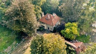 In een groene, rustige omgeving, op wandelafstand van winkels en scholen, vind je deze karaktervolle villa uit de jaren ’40.<br />De woning biedt 310 m² bewoonbare oppervlakte, en is volledig onderkelderd en ligt op een riant perceel van 2.267 m².<br /><br />Binnen word je verwelkomd door een ruime inkomhal met klassieke traphal en authentieke details zoals glas-in-loodramen, massief houtwerk en een monumentale open haard.<br />De leefruimtes baden in natuurlijk licht en ademen een warme, tijdloze sfeer.<br />De keuken kijkt uit op de tuin en biedt voldoende ruimte voor een hedendaagse herinrichting.<br /><br />Op de verdieping bevinden zich meerdere ruime slaapkamers met parketvloeren en originele details. De woning beschikt verder over een grote kelderverdieping en tal van uitbreidingsmogelijkheden.<br /><br />Het perceel van meer dan 22 are garandeert privacy, rust en groen rondom de woning — ideaal voor wie houdt van ruimte of extra plannen heeft (zwembad, bijgebouw, atelier).<br /><br />Met een EPC-label F vraagt deze woning om een energetische renovatie, maar biedt ze tegelijk uitzonderlijk potentieel voor wie houdt van charme, authenticiteit en karaktervolle architectuur.<br /><br />Troeven:<br />- Unieke villa met karakter (bouwjaar ±1940)<br />- Bewoonbare oppervlakte: ±310 m² + kelder 100 m²<br />- Groot perceel: 2.267 m²<br />- Rustige maar bereikbare ligging, nabij centrum Lokeren<br />- Authentieke details (houtwerk, glas-in-lood, haard)<br />- Uitbreidingsmogelijkheden (mits vergunning)<br />- Goede verbinding met Gent, Sint-Niklaas en Antwerpen<br /><br />Adres: Oude Heerweg 105, 9160 Lokeren<br />EPC-label: F<br />Beschikbaar: bij akte<br /><br />Interesse in deze unieke woning met toekomst? Contacteer Sam op 0475 22 23 22 of via sam@woonvast.be