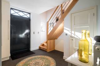 <p><strong>Instapklare en bijzonder verzorgde villa met 4 slaapkamers, 2 badkamers, kantoorruimte, 2 garages en carport, gelegen op een mooie locatie in Ravels. De woning bevindt zich op een west georiënteerd perceel met een volledig afgesloten tuin en een heerlijk overdekt terras. Dankzij de doordachte indeling, de kwalitatieve afwerking en de gunstige energiescore van 115 KwH is dit een ideale gezinswoning waar u zonder zorgen kunt intrekken.</strong></p>
<p>Een prachtige inkomhal heet u van harte welkom. Meteen bij het binnenkomen valt op met hoeveel zorg en oog voor detail deze woning werd ingericht en onderhouden. De inkomhal is voorzien van een vestiaire, gastentoilet en trap naar de verdieping en geeft rechtstreeks toegang tot de leefruimte. De woonkamer is aangenaam ingedeeld in een gezellige zithoek aan de straatzijde en een ruime eetkamer aan de tuinzijde. Een stijlvolle roomdivider zorgt voor een subtiele scheiding tussen beide ruimtes, terwijl u zowel vanuit de zithoek als vanuit de eetkamer kunt genieten van de warmte en sfeer van de haard. Grote raampartijen zorgen bovendien voor een mooie natuurlijke lichtinval en een prettig contact met de tuin. Aansluitend bevindt zich de zeer verzorgde keuken, die dankzij haar open verbinding met de eetkamer bijzonder gezellig aanvoelt. Terwijl u kookt, blijft u betrokken bij uw gezin of gasten en ook voor een aperitief aan het ruime werkblad is er meer dan voldoende plaats. De keuken verkeert in uitstekende staat en is voorzien van een groot werkblad, de nodige inbouwtoestellen en veel praktische bergruimte. Naast de keuken bevindt zich de ruime bijkeuken, ingericht met plaats voor wasmachine en droogkast, extra opbergmogelijkheden en een volwaardige douche. Een absolute meerwaarde is de recent ingerichte kantoorruimte. Deze werd stijlvol afgewerkt met maatwerkkasten en een fraai fineer werkblad met ruimte voor twee werkplekken. Dankzij de stalen ramen en deur blijft het contact met de leefruimte behouden, terwijl u de ruimte indien gewenst rustig kunt afsluiten.</p>
<p><strong>Verdieping <br /></strong>Via de lichtrijke overloop bereikt u drie ruime slaapkamers, een volledig vernieuwd apart toilet en de badkamer. De master bedroom bevindt zich aan de tuinzijde en geniet van een mooi uitzicht over het groen. Deze kamer beschikt over airconditioning en een ruime inloopdressing. Ook de overige slaapkamers zijn volwaardig van formaat, waarbij de grootste slaapkamer zich aan de straatzijde bevindt. De volledig vernieuwde badkamer is bijzonder stijlvol afgewerkt. De natuurlijke lichtinval en de hoogwaardige materialen zorgen voor een luxueuze uitstraling. De badkamer is uitgerust met een dubbele wastafel en een zeer ruime inloopdouche, waardoor u hier elke dag van een echt wellnessgevoel geniet.</p>
<p><strong>Zolderverdieping <br /></strong>Ook de zolderverdieping werd optimaal benut en is gemakkelijk bereikbaar via een vaste trap. Hier bevindt zich een ruime vierde slaapkamer die eveneens uitstekend dienst kan doen als hobby-, speel- of werkruimte. Daarnaast zijn er nog twee royale bergruimtes aanwezig. Zelfs deze ruimtes werden netjes en duurzaam afgewerkt.</p>
<p><strong>Tuin <br /></strong>buiten is het heerlijk vertoeven. Het west georiënteerde perceel laat u volop genieten van de namiddag- en avondzon. Het ruime overdekte terras vormt daarbij een echte verlenging van de leefruimte. Op warme dagen geniet u er aangenaam in de schaduw, terwijl u dankzij de aanwezige verwarming ook tijdens koelere momenten comfortabel buiten kunt blijven zitten. Vanop het terras kijkt u uit over de verzorgde, groene tuin, waar u bijzonder rustig en discreet zit. De tuin is volledig afgesloten en daardoor ideaal voor gezinnen met kinderen of huisdieren. Achteraan bevinden zich bovendien twee garages en een carport, waardoor er bijzonder veel parkeer- en opslagruimte beschikbaar is. Eén van de garages beschikt daarnaast over een volwaardige kelder.</p>
