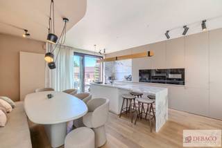 Debaco Immobiliën presenteert dit uitzonderlijk appartement waar ruimte, luxe en verfijning naadloos samenvloeien. Met een bewoonbare oppervlakte van circa 220 m², drie royale terrassen en een hoogwaardige afwerking tot in de kleinste details, biedt deze exclusieve residentie een unieke woonervaring op een uitstekende locatie, vlakbij het bruisende centrum van Leuven. <br /><br />Van zodra u het appartement betreedt, wordt u ondergedompeld in een gevoel van elegantie, luxe en exclusiviteit! <br /><br />De indrukwekkende leefruimte, afgewerkt met een warme parketvloer en een stijlvolle gashaard, vormt het kloppende hart van het appartement. Aansluitend bevindt zich de luxueuze open keuken, volledig uitgerust met kwalitatieve en hedendaagse toestellen en afgewerkt met oog voor detail. De ruime eetplaats vormt de ideale setting voor gezellige diners en stijlvolle ontvangsten en maakt het geheel compleet. <br /><br />Vanuit de leefruimte bereikt u het eerste royale terras, waar u in alle rust kunt genieten van een exclusieve buitenbeleving. Hier is voldoende ruimte voorzien voor zowel een stijlvolle lounge als een volwaardige buiteneetkamer. <br /><br />Het appartement beschikt over zes volwaardige slaapkamers, die stuk voor stuk een aangename rust uitstralen en afgewerkt zijn met kwalitatieve vast tapijtbekleding. <br /><br />De absolute blikvanger is de mastersuite. Deze ruimte beschikt over een elegant bureaugedeelte, een royale dressing en een luxueuze ensuite badkamer met een ruime inloopdouche, een dubbel lavabomeubel en een afzonderlijk toilet. Vanuit de mastersuite geniet u bovendien van een rechtstreekse toegang tot twee bijkomende terrassen, waardoor u op elk moment van de dag kunt genieten van zon, rust en privacy. <br /><br />De nachthal biedt vervolgens toegang tot een praktische wasberging, twee afzonderlijke gastentoiletten en twee badkamers. <br /><br />Bij dit appartement horen ook drie privatieve autostaanplaatsen in de ondergrondse parkeergarage en twee ruime kelderbergingen. Het appartement is comfortabel bereikbaar via de lift. <br /><br />Troeven: <br />+ Exclusief high-end appartement<br />+ Hoogwaardige en luxueuze afwerking<br />+ Royale leefruimte met luxueuze keuken<br />+ 6 slaapkamers <br />+ Mastersuite met dressing en ensuite badkamer <br />+ 3 ruime terrassen <br />+ 3 privatieve ondergrondse staanplaatsen <br />+ EPC label A - EK conform <br />+ Uitstekende locatie te Leuven<br /><br />Hebt u interesse in dit exclusief appartement te Leuven? <br />Contacteer ons via info@debaco.be of bel ons op 014/73.77.77 voor een bezoek ter plaatse!