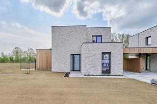 <strong>Welkom op NIEUWBOUWZONDAG op 26 april van 14 uur tot 16 uur!<br /><br />Nieuwe verkaveling in Neeroeteren</strong> aan de voormalige melkerij <span>bestaande uit <strong>2 woningen op grote percelen</strong>, met achterliggende </span>grond.<br /><br />De percelen liggen op een boogscheut van het centrum van Neeroeteren met een supermarkt en school op 500 meter. Hier woon je mooi met de achterzijde grenzend aan de Tapziekbeek, wat voor een extra natuurlijk karakter van de tuinen zorgt. Op de percelen achter de Tapziekbeek kan er volgens de verkavelingsvoorschriften niet gebouwd worden, wat betekent dat het groene karakter behouden zal blijven. <br /><br /><span><strong>Lot 2</strong></span> is een <span><strong>open doorzonwoning</strong></span> met carport.<br />- doorzonwoning: 160,70m²<br />- oppervlakte bouwperceel: 7a88ca + oppervlaktes achterliggende percelen grond (Lot 6 en Lot 7): 14a02ca en 15a04ca<br />- terras: 24,52m²<br /><br /><strong>Gelijkvloers:</strong><br />- inkomhal met apart toilet<br />- leefruimte met veel lichtinval en open keuken<br />- aparte berging/wasplaats<br />- 1 slaapkamer met badkamer met enkel badkamermeubel en douche<br />- groot terras met zuidgerichte tuin<br /><br /><strong>Verdieping:</strong><br />- 3 slaapkamers<br />- 1 badkamer met dubbel badkamermeubel en douche<br />- apart toilet<br />- technische ruimte<br /><br />De woning werd volledig afgewerkt met kwalitatieve materialen en is geschilderd. Er is een carport aan de rechterzijde van de woning met een laadpunt voor de auto. Er is overal vloerverwarming aanwezig en er zijn zonnepanelen voorzien. Grote troef is het <strong>zeer gunstig E-peil van maximum 10</strong>. <span>Omdat het E-peil <10 is, moet de koper gedurende 5 jaar geen kadastraal inkomen betalen. De buitenverhardingen en de tuin zijn aangelegd.</span><br /><br /><span>De<strong> overige achterliggende percelen grond</strong> (Lot 8, 9 en 10) kunnen optioneel ook bij aangekocht worden.</span><br /><br />Ben jij op zoek naar een rustig gelegen nieuwbouwwoning in het groen met veel grond? Maak dan snel een afspraak voor een bezoek!<br /><br />Vermelde prijs is exclusief registratie, BTW en notariskosten. Neem snel contact op voor meer info. Wij ontzorgen je ook voor <strong>de verkoop</strong> van <strong>je huidige woning</strong>! Voor meer uitleg helpen we je graag verder.