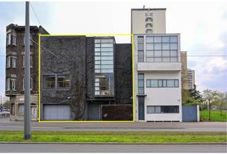 <br />Cette maison moderne, conçue par l'architecte belge Georges Baines, symbolise le modernisme intemporel en harmonie avec l'architecture fonctionnelle. La propriété partage son emplacement unique avec l'emblématique « Maison Guiette », l'un des premiers modèles théoriques de maison de Le Corbusier. Ce chef-d'œuvre, en partie inspiré de l'architecture médiévale flamande traditionnelle, est la seule œuvre de Le Corbusier conservée en Belgique. Ensemble, ces joyaux architecturaux forment un magnifique ensemble au sein d'un ensemble plus vaste et impressionnant.<br /><br />La maison dispose d'une superficie spacieuse de plus de 700 m², répartie sur plusieurs niveaux, et est idéale pour un usage de bureau avec stockage. Située dans un emplacement central à l'arrière du Nachtegalenpark à Wilrijk, la maison est facilement accessible, avec des connexions directes à l'A12 et à seulement 1,5 km de la R1 et de la R10.<br />Le rez-de-chaussée d'environ 215 m² comprend un hall d'entrée spacieux, un escalier, un ascenseur, un garage intérieur et une grande pièce avec cuisine. À l'arrière du bâtiment se trouve un espace bureau avec accès au jardin. Le sous-sol offre un espace fermé d'environ 130 m².<br /><br />Le premier étage est une pièce polyvalente de 180 m² avec des placards intégrés, une kitchenette et des toilettes. <br /><br />Le deuxième étage est un véritable joyau : un grand espace de 180 m² avec parquet et hauts plafonds jusqu'à la charpente, équipé de la climatisation. Grâce à ses grandes baies vitrées, cet espace bénéficie d'une lumière naturelle abondante, ce qui contribue à créer une atmosphère inspirante. Une mezzanine de 60 m² offre un espace supplémentaire et renforce l'ouverture de cet étage. Un escalier séparé relie l'atelier à un espace de rangement supplémentaire de 30 m².<br /><br />Atouts :<br />- Excellent emplacement<br />- Ascenseur disponible<br />- Climatisation disponible au deuxième étage<br />- Parking dans le bâtiment