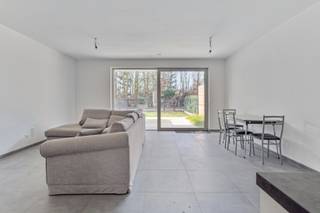 Nieuwbouw appartement onder registratierechten (2% of 12%) ! <br /><br />Dit prachtige, recent gelijkvloers appartement met 1 slaapkamer en een gezellig tuintje bevindt zich op wandelafstand van het centrum en heeft een uitstekende verbinding met de omliggende gemeenten.<br /><br />Bij binnenkomst via de inkomhal, die een vestiaire en gastentoilet biedt, komt u in leefruimte met een open keuken. Deze keuken is uitgerust met kwalitatieve toestellen, zoals een koelkast, vaatwasser, combi-oven, inductiekookplaat, afzuigkap en spoeltafel, en biedt voldoende opbergruimte. De berging naast de keuken kan praktisch worden ingedeeld. Door het grote schuifraam bereikt u de zonovergoten tuin met een gezellig overdekt terras. De tuin is volledig omheind en toegankelijk via het achterliggende fietspad.<br /><br />Het appartement beschikt over een ruime slaapkamer, waarin grote kasten makkelijk kunnen worden geplaatst. De aangrenzende badkamer is voorzien van een betegelde inloopdouche en een wastafel in meubel.<br /><br />Het gebouw is energiezuinig en uitgerust met een ventilatiesysteem type D, een warmtepomp, zonnepanelen en vloerverwarming.<br /><br />Als extra voordeel is er een ruime autostaanplaats met laadpaal in de kelder, evenals een privatieve berging aan de achterkant van het perceel. Deze zijn verplicht bij te kopen aan € 20.000.