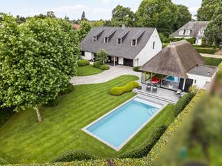 La Ferme Blanche | Luxe intemporelle et savoir-faire exceptionnel<br /><br />Située sur la Hoogstraatsesteenweg à Rijkevorsel, La Ferme Blanche est une propriété exceptionnelle où le luxe intemporel et le savoir-faire sont au cœur de tout. La ferme d'origine de 1931 a été entièrement repensée en 2015 pour devenir une villa élégante de plus de 400 m², finie avec une attention portée aux détails que l'on trouve rarement aujourd'hui. En 2019, le tout a été complété par un poolhouse exclusif, créant ainsi un environnement de vie unique où habiter, se détendre et profiter cohabitent harmonieusement.<br /><br />Dès le premier contact, la qualité exceptionnelle des finitions est évidente. Des matériaux de haute qualité, des aménagements sur mesure raffinés, de la pierre naturelle, des portes intérieures en acier et un éclairage intégré soigneusement créent un ensemble harmonieux où la qualité est palpable dans chaque pièce. De plus, la propriété est impeccablement entretenue et se présente aujourd'hui comme si elle venait d'être réalisée.<br /><br />Située sur une parcelle entièrement clôturée de 1 165 m², vous bénéficiez ici d'une combinaison très agréable de confidentialité, de confort et d'accessibilité. Derrière les portails électriques, un domaine soigneusement aménagé se déploie, où des haies matures, des pelouses parfaitement entretenues et des structures vertes bien pensées créent une atmosphère apaisante et exclusive.<br /><br />En passant par le hall d'entrée, vous entrez dans le cœur de la maison, où les différents espaces de vie se fondent naturellement les uns dans les autres. Grâce aux grandes baies vitrées, chaque pièce bénéficie d'une abondance de lumière naturelle et d'une forte connexion avec le jardin.<br /><br />Le salon chaleureux avec cheminée en bois forme un espace de vie chaleureux et accueillant où le calme et le confort sont au centre de tout. Les grandes baies vitrées offrent une vue magnifique sur le jardin et créent une transition fluide vers la terrasse couverte.<br /><br />Juste à côté se trouve la cuisine intemporelle équipée d'appareils de qualité de marques telles que Miele et Siemens. L'îlot central forme un lieu de rencontre convivial tandis que les plans de travail en granit Jasberg soulignent la finition de qualité de la pièce. Un cellier pratique offre de l'espace supplémentaire pour les appareils de réfrigération et de congélation et facilite l'utilisation quotidienne.<br /><br />Au rez-de-chaussée se trouve également un grand bureau aménagé sur mesure. Grâce à son emplacement calme, cet espace constitue l'endroit idéal pour travailler et vivre en même temps. En outre, le rez-de-chaussée dispose d'une salle de bain avec douche, de toilettes d'invités séparées, d'une buanderie, d'une chaufferie et d'un garage intégré avec point de charge pour véhicules électriques.<br /><br />Par le hall d'escalier, vous accédez à l'étage, entièrement aménagé avec confort et fonctionnalité à l'esprit. Vous y trouverez trois chambres à coucher complètes. Le palier a été équipé d'armoires encastrées qui s'intègrent parfaitement dans l'intérieur. La salle de bain spacieuse est équipée d'un double lavabo, d'une baignoire indépendante et d'une finition de qualité qui s'harmonise parfaitement avec le reste de la maison.<br /><br />Un atout particulier à cet étage est l'immense espace polyvalent. Celui-ci peut être aménagé selon vos envies en salle de jeux, salle de fitness, espace de loisirs, salon supplémentaire ou chambre d'amis. Un escalier escamotable mène également à un grenier séparé, offrant ainsi un espace de rangement pratique.<br /><br />À l'extérieur également, la même norme de qualité sans compromis a été maintenue. La terrasse couverte est une véritable extension de l'espace de vie et offre une vue magnifique sur