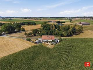 Op slechts 15 minuten van Ieper, midden in het prachtige Heuvelland en meer bepaald in Wijtschate, bevindt zich deze landelijk gelegen alleenstaande woning. De woning ligt verscholen in een rustig zijstraatje en is bovendien de enige woning in de straat. Wie droomt van rust, privacy en landelijk wonen, is hier dan ook aan het juiste adres ;-). <br /><br />Het betreft een <strong>zonevreemde woning</strong> waardoor de regelgeving inzake zonevreemde woningen van toepassing is. Concreet betekent dit dat de woning, mits het verkrijgen van de nodige vergunningen, kan worden uitgebreid tot een maximaal bouwvolume van 1.000 m³. Daarnaast behoort ook een bijgebouw tot 40 m² tot de mogelijkheden. Ter vergelijking: het huidige bouwvolume van de woning bedraagt circa 702 m³.<br /><br /><strong>Indeling van het pand</strong>
<ul>
	<li>Gelijkvloerse verdieping: voormalige inpandige garage wordt momenteel gebruikt als inkomhal met toilet (19 m²), keuken (13 m²) met aansluitend de woon- en eetkamer (28 m²), 2 kamers (11 - 10 m²), berging (10 m²), stookruimte (4 m²), badkamer (3 m²) en veranda (12 m²) </li>
	<li>Eerste verdieping: nachthal, 2 slaapkamers (16 - 9 m²) en zolder (32 m²). </li>
</ul>
<br /><strong>Kenmerken </strong>

<ul>
	<li>Zuidoostgerichte tuin</li>
	<li>Overal reeds voorzien van dubbele beglazing, grotendeels met aluminium schrijnwerk</li>
	<li>Steenput, regen- en stadswater aanwezig </li>
</ul>
<br />Check zeker ook de video: https://youtube.com/shorts/v7LXFkJvb_c?feature=share<br /><br />Meer informatie of een vrijblijvend bezoek? Contacteer Eden op 0470 43 78 21 of mail info@minthus.be