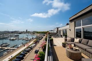 Ontdek deze exclusieve penthouse met panoramisch uitzicht over de jachthaven én achterhaven van Zeebrugge. Een uitzonderlijke woonbeleving met ongeëvenaarde zichten, royale zonneterrassen en een luxueuze afwerking tot in de kleinste details.
Via een stijlvolle inkomhal komt u binnen in een indrukwekkende leefruimte met hoge plafonds, grote raampartijen en directe toegang tot twee ruime terrassen. De overvloed aan natuurlijk licht, gecombineerd met het open uitzicht, creëert een unieke sfeer van rust en verfijning.
De moderne open keuken met centraal eiland is volledig uitgerust met hoogwaardige toestellen en biedt alle comfort. Een aparte leeshoek en een gezellige haard zorgen voor een warme en huiselijke sfeer.
De penthouse beschikt over drie volwaardige slaapkamers, telkens voorzien van ingemaakte kasten en rechtstreekse toegang tot de terrassen. Twee stijlvolle badkamers – één met ligbad en één met inloopdouche – garanderen dagelijks comfort. Daarnaast zijn er twee aparte toiletten en een praktische berging.
Extra troef: mogelijkheid tot aankoop van een bovengrondse dubbele garagebox.
Bent u op zoek naar een uniek en luxueus verblijf aan de jachthaven van Zeebrugge? Aarzel dan niet om contact op te nemen met makelaar Stéphanie via 0472 77 86 60 of stephanie@keyimmo.be voor een exclusief bezoek.